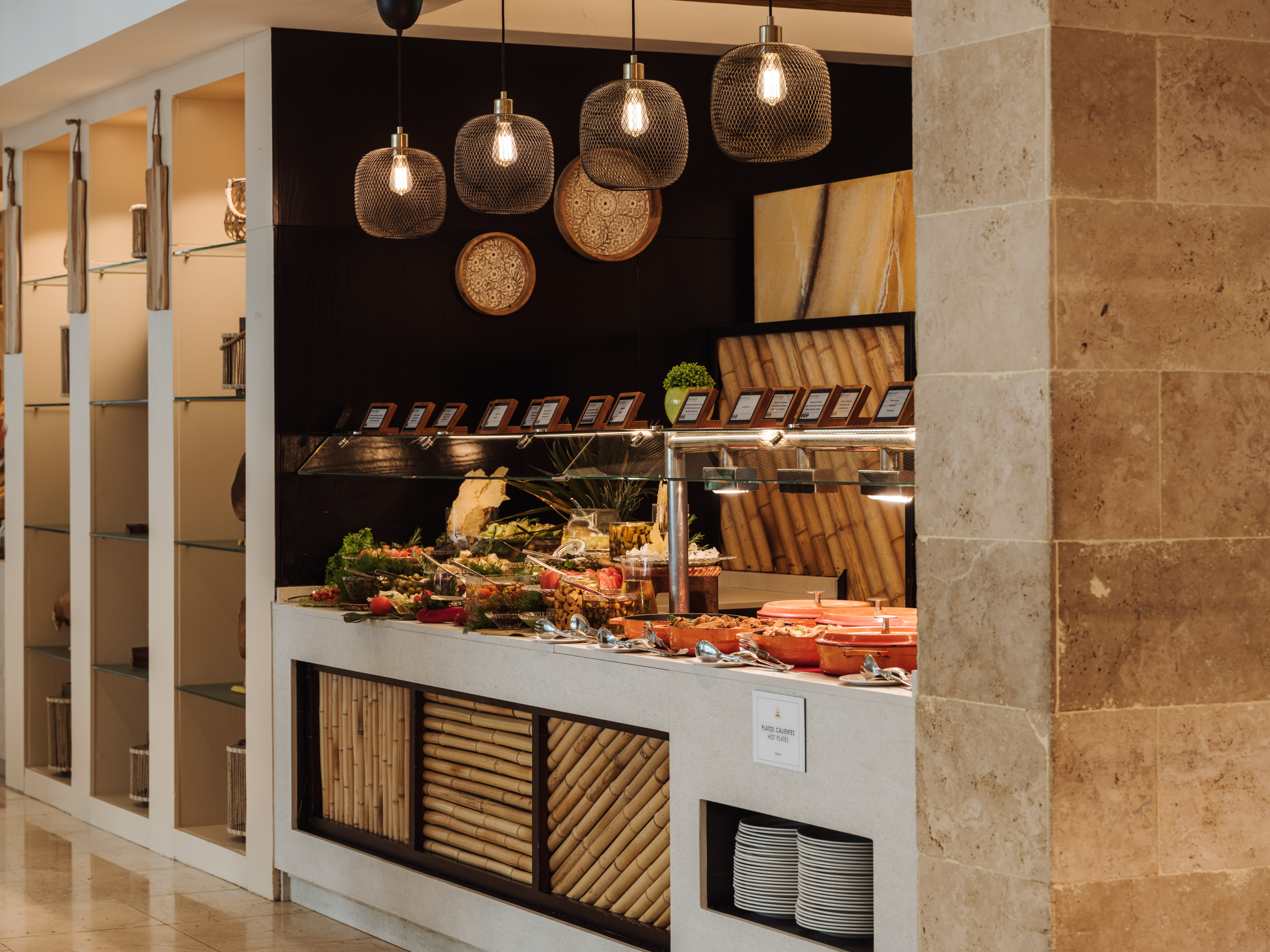 Elegant hotel buffet with hot plates, fresh salads, and modern pendant lighting.