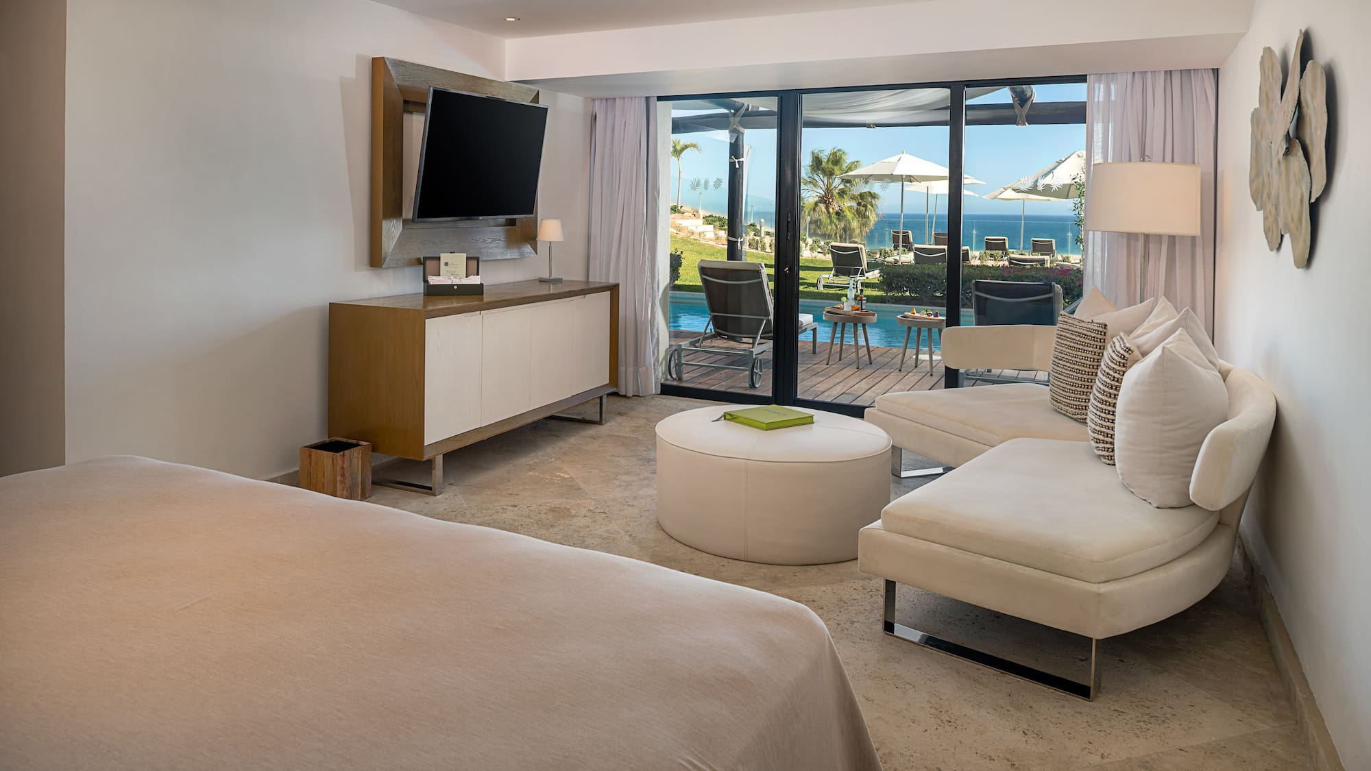 a room with a television and a view of the ocean