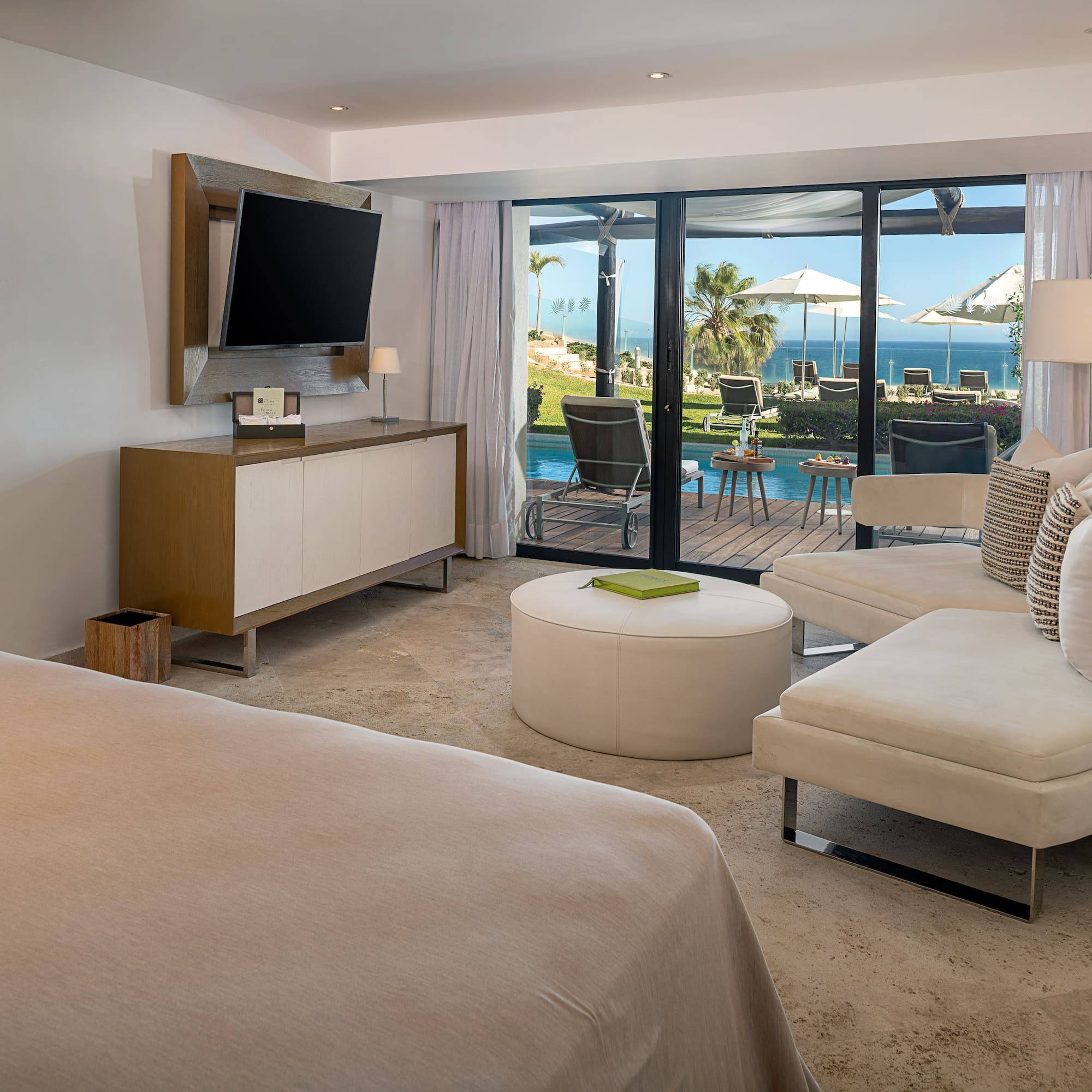 a room with a television and a view of the ocean