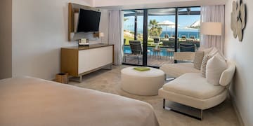 a room with a television and a view of the ocean