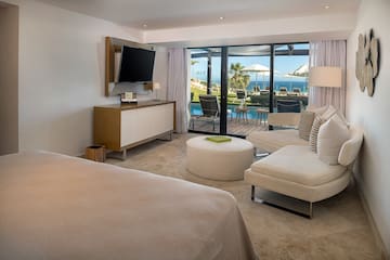 a room with a television and a view of the ocean