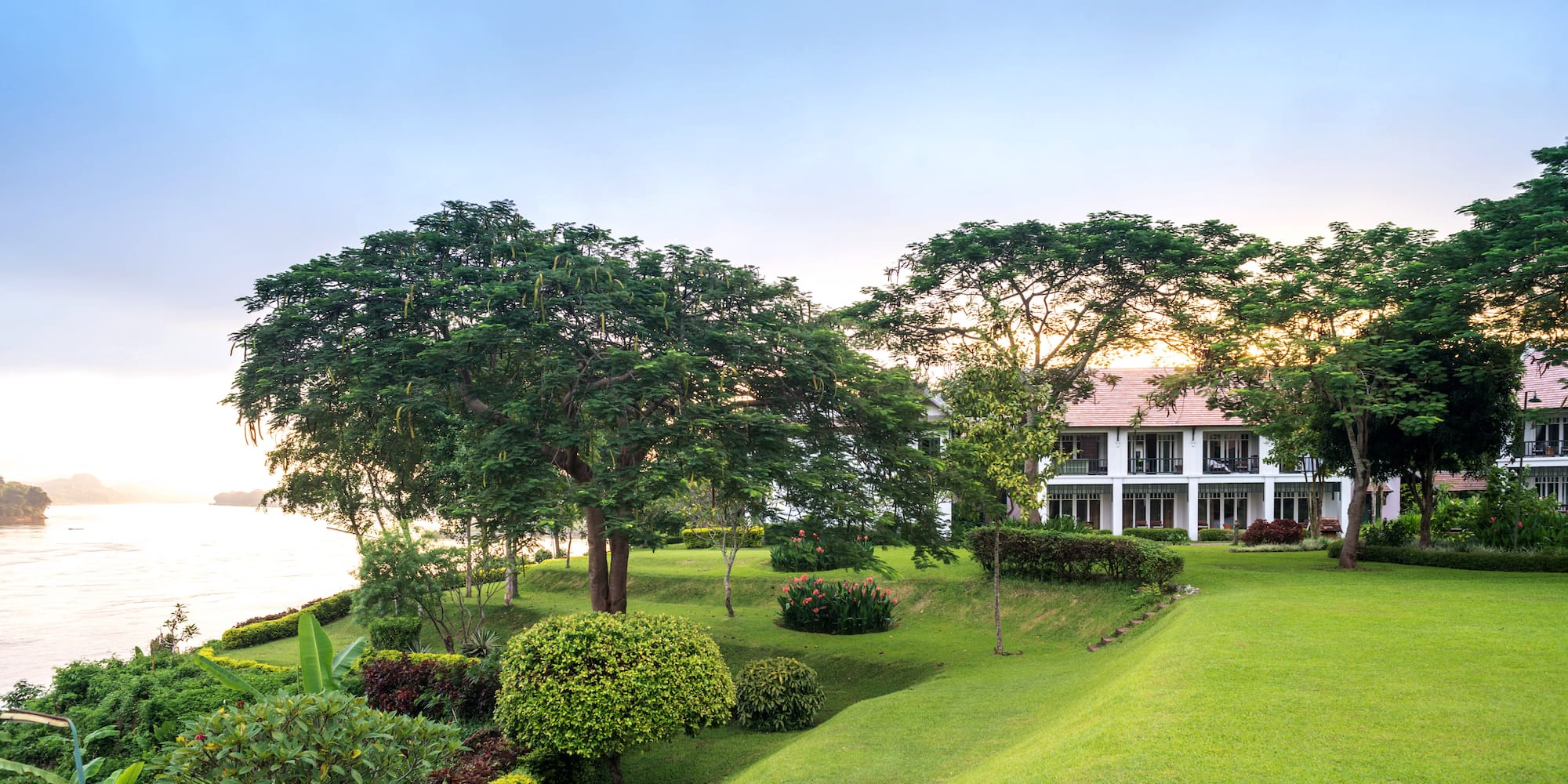 a house with a large lawn and trees