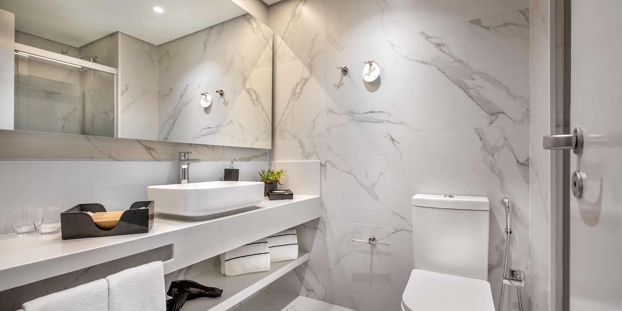 a bathroom with marble walls and a sink and toilet