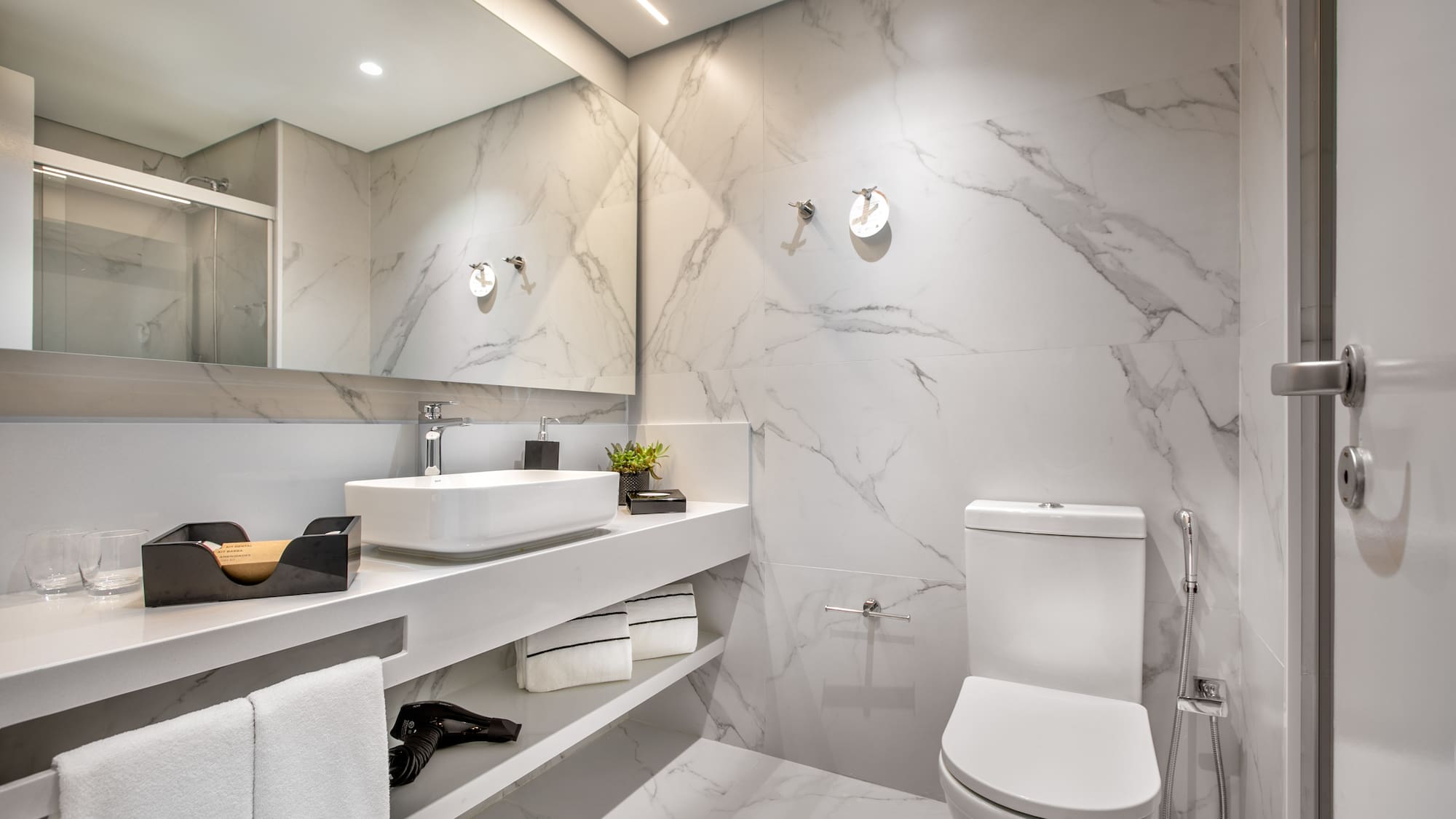 a bathroom with marble walls and a sink and toilet
