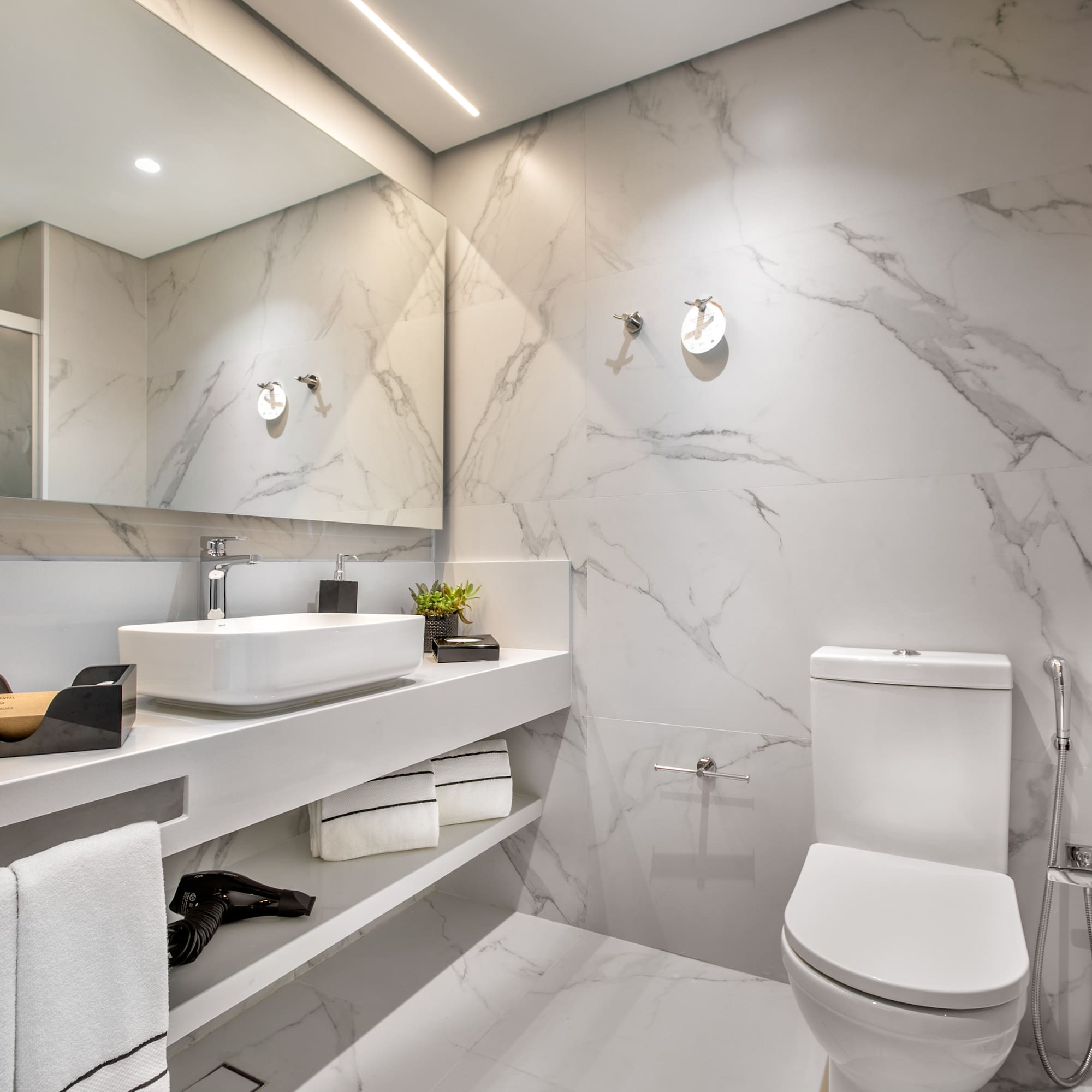 a bathroom with marble walls and a sink and toilet