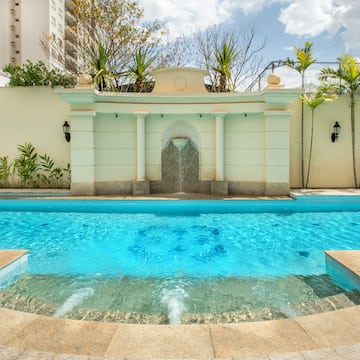 a pool with a fountain and a fence