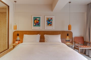 a bed with a wood headboard and two lamps above it