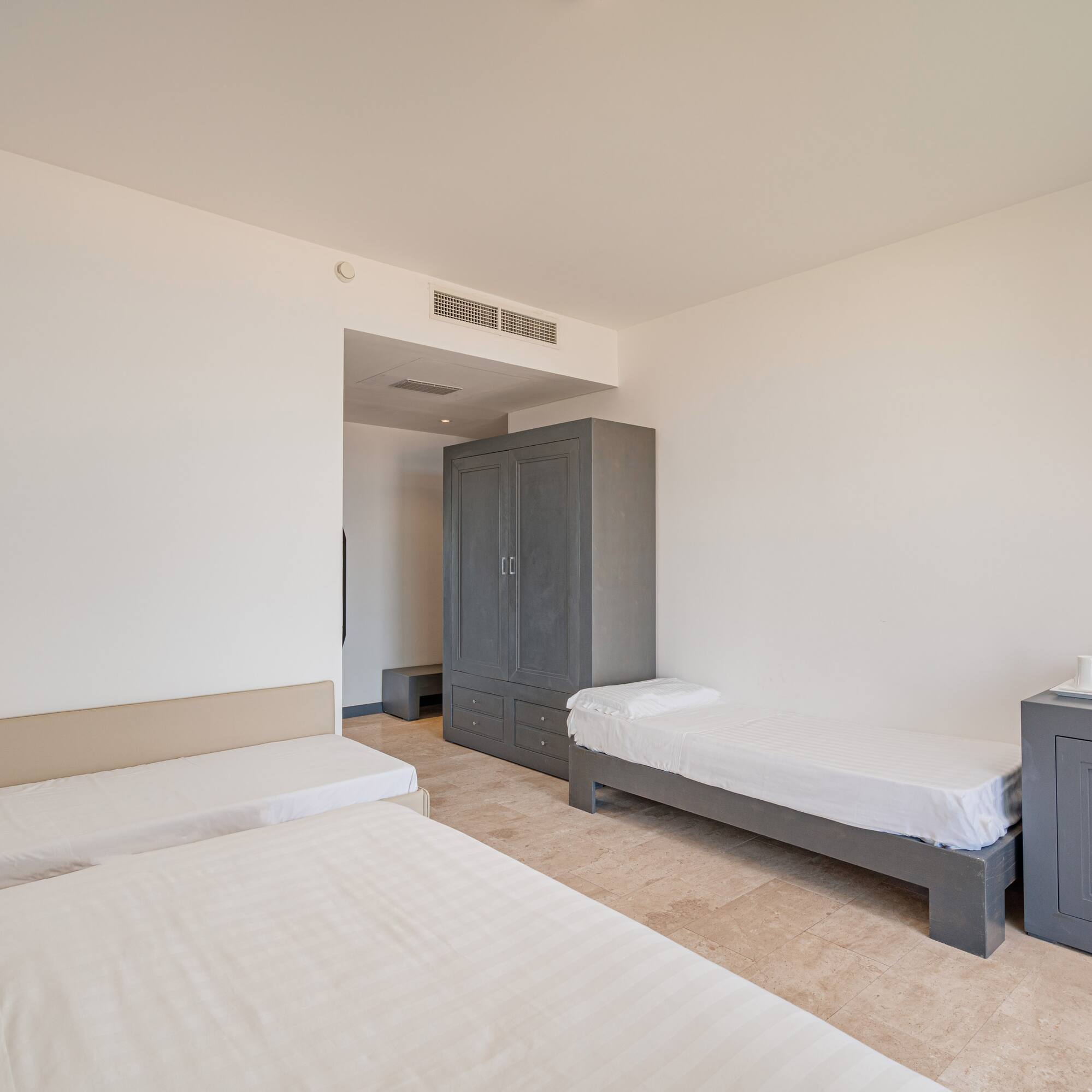 a room with two beds and a cabinet