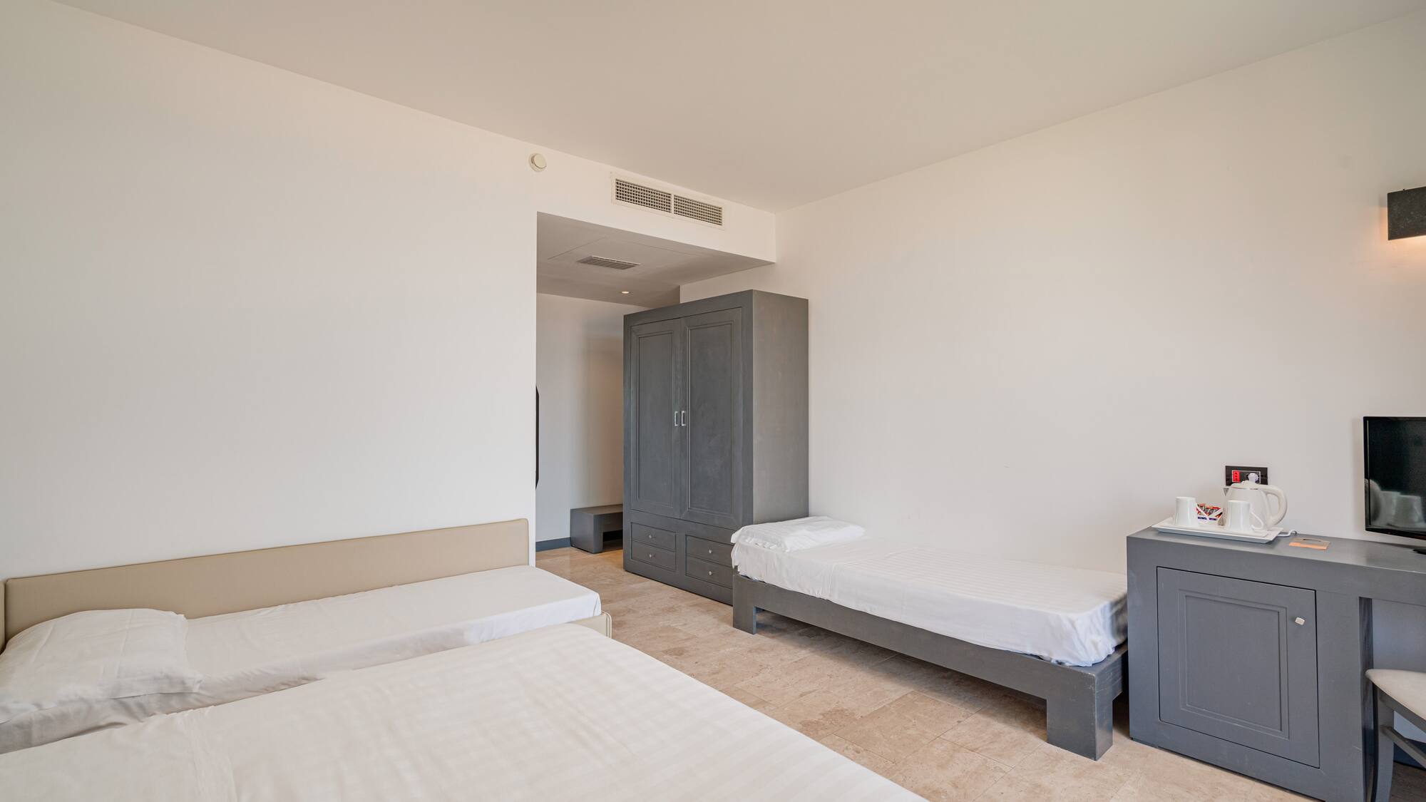 a room with two beds and a cabinet