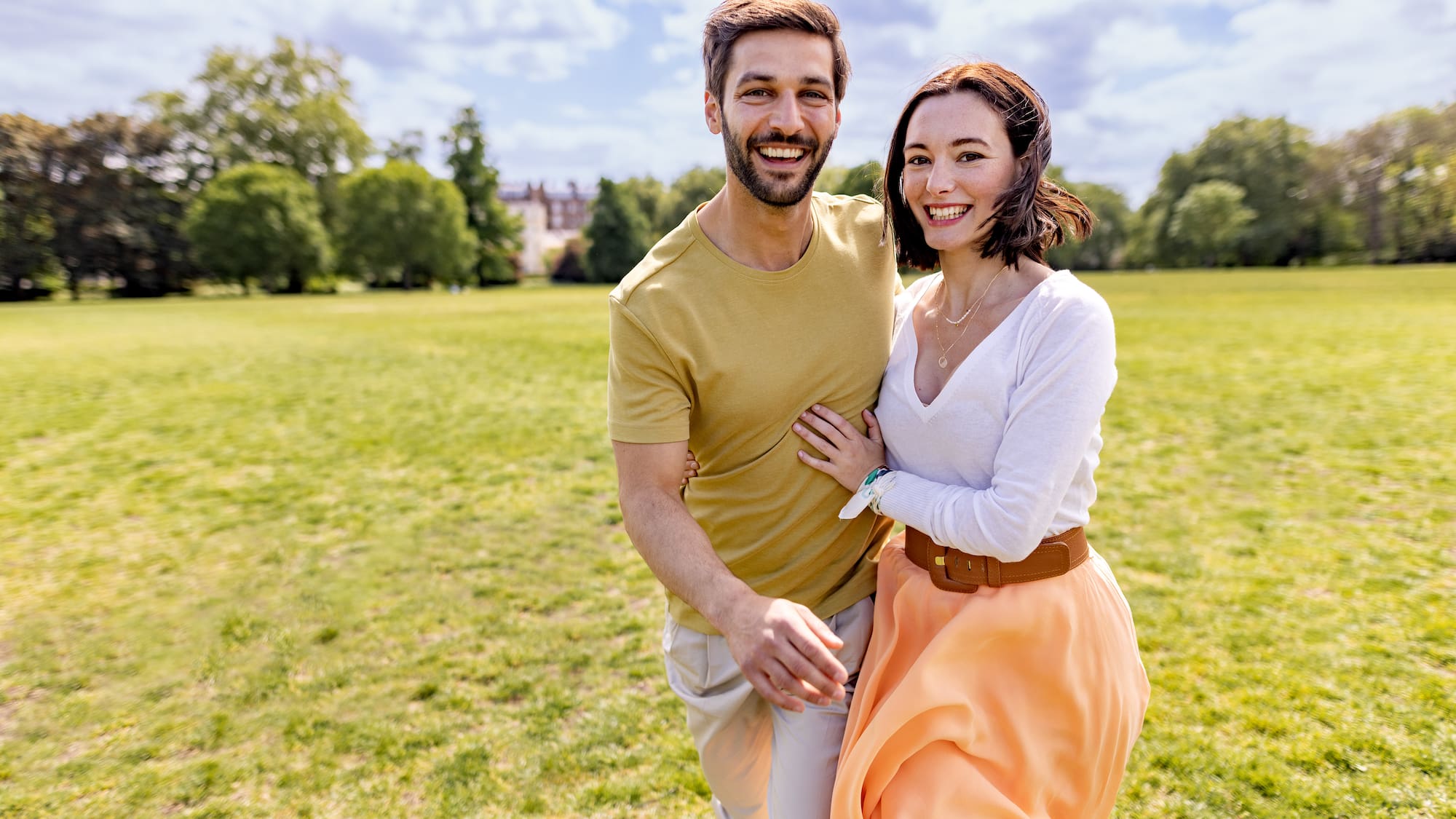 a man and woman standing in a grassy field