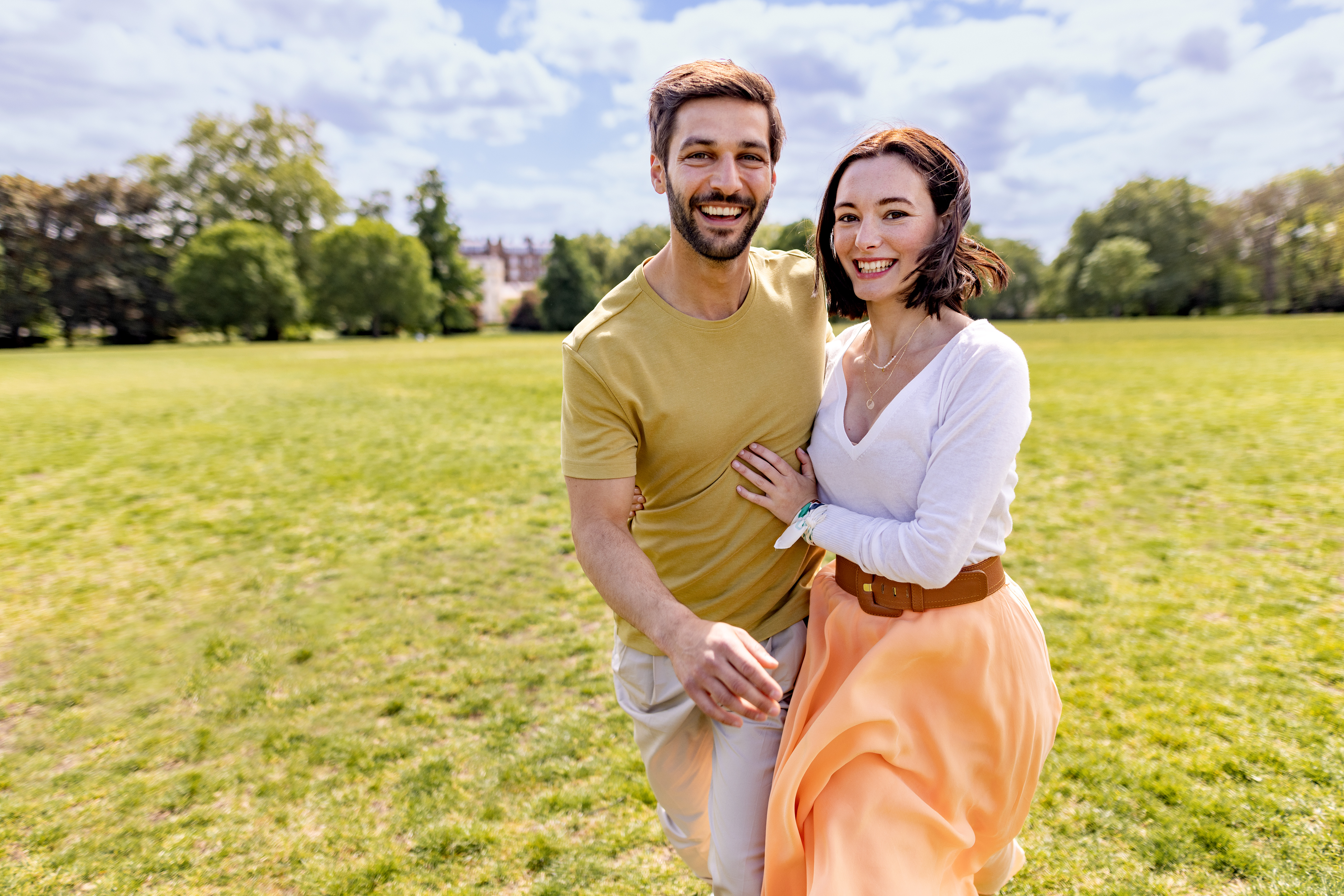 a man and woman standing in a grassy field