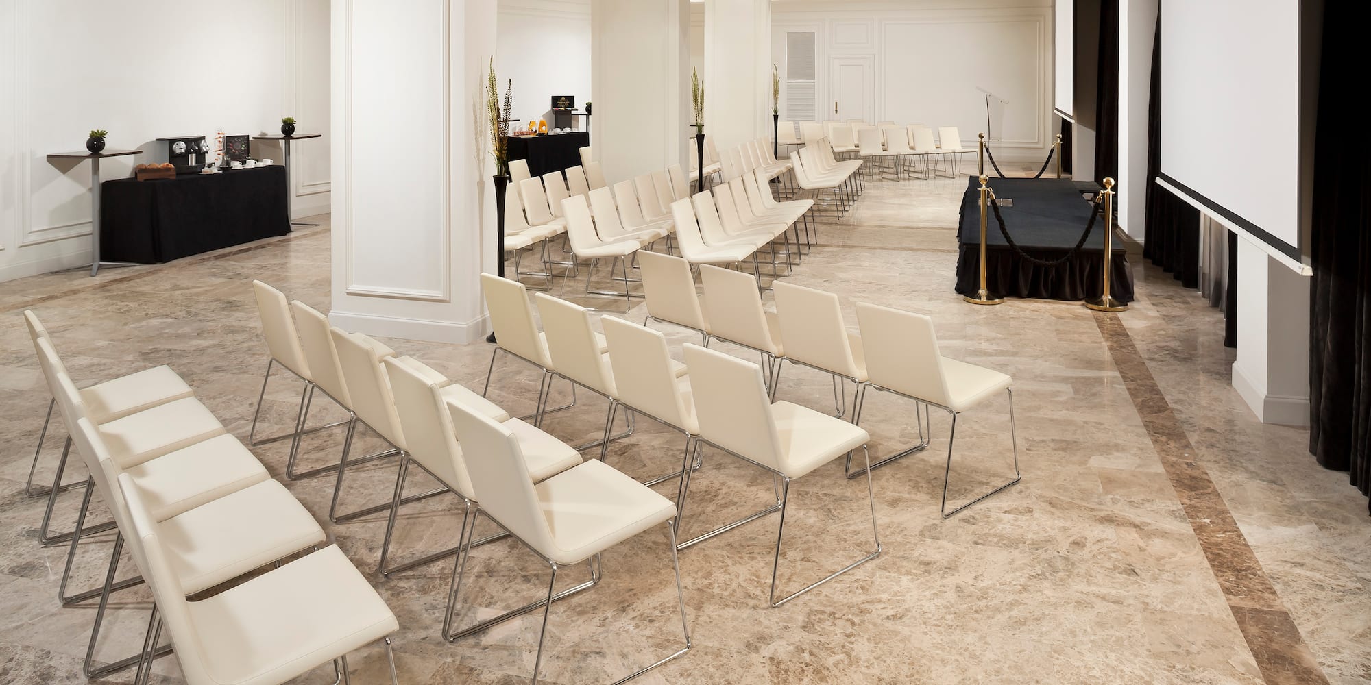 a room with white chairs and a black table