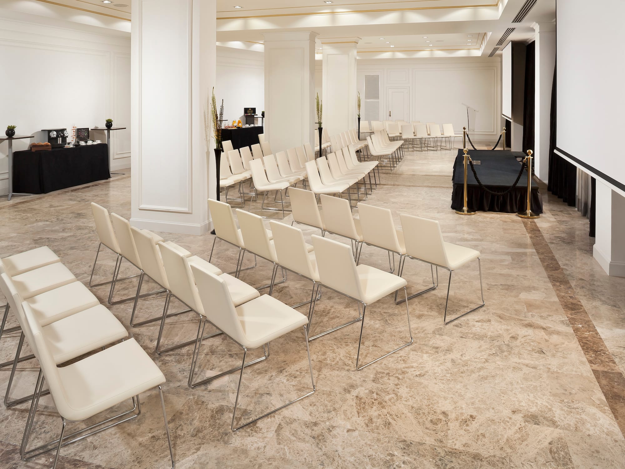 a room with white chairs and a black table