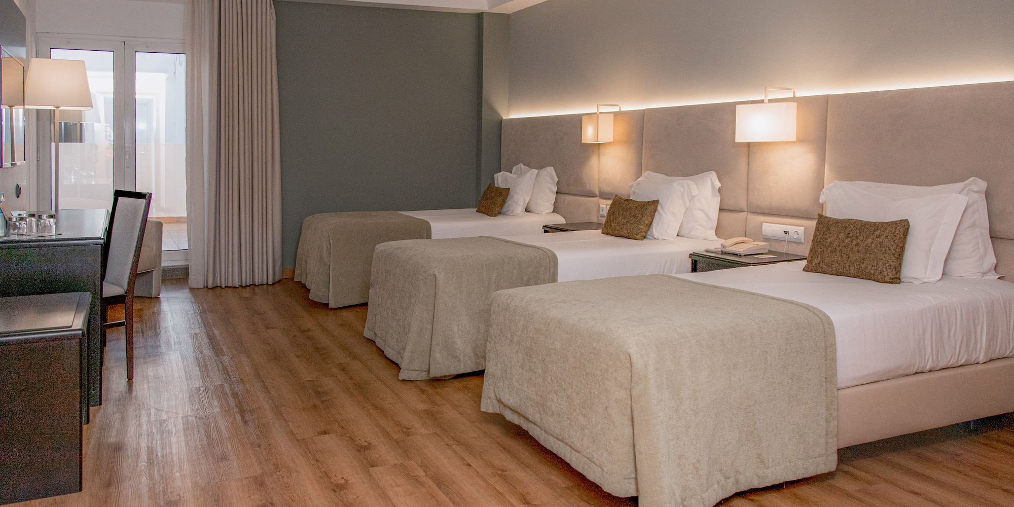 a room with beds and a wood floor