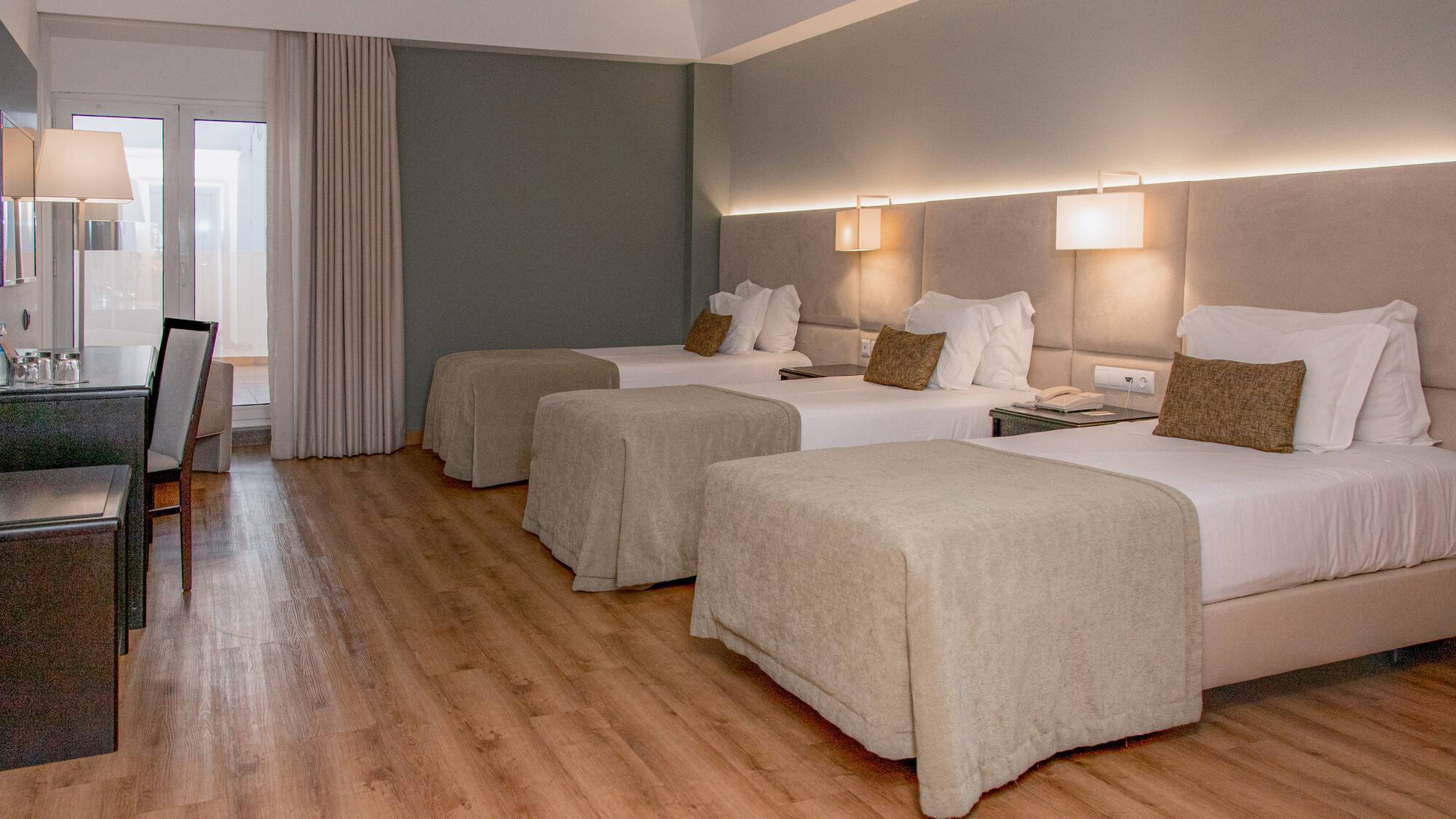 a room with beds and a wood floor