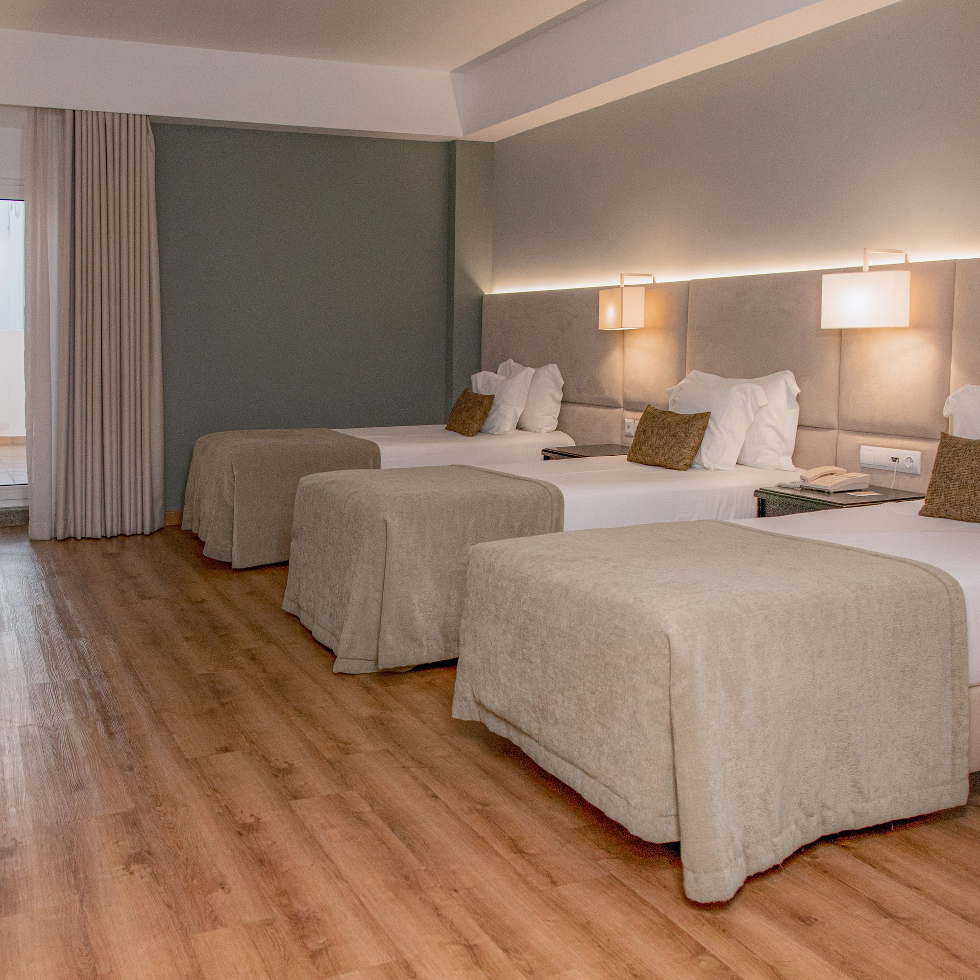 a room with beds and a wood floor