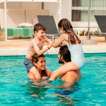 a man and woman with children in a pool