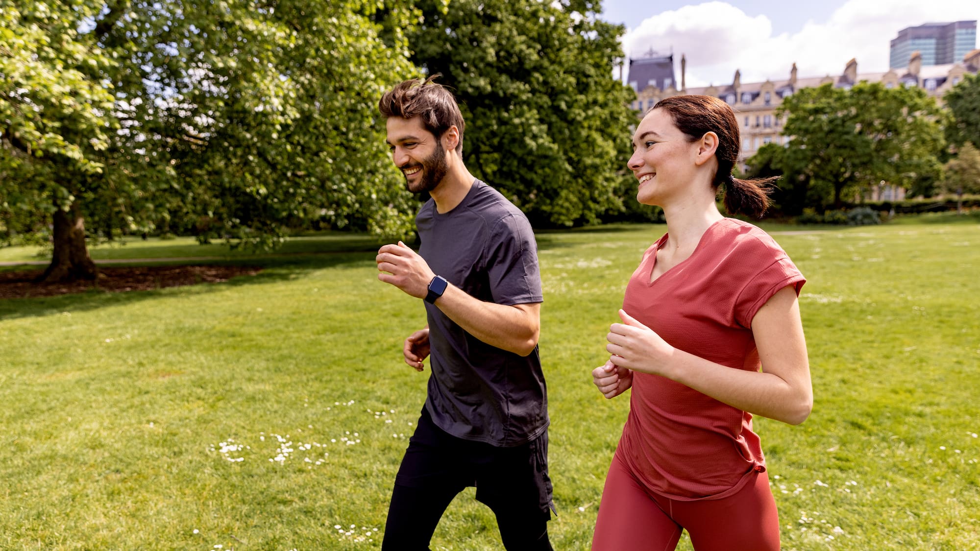 a man and woman running in a park