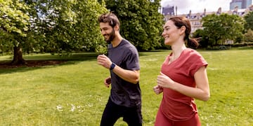 a man and woman running in a park