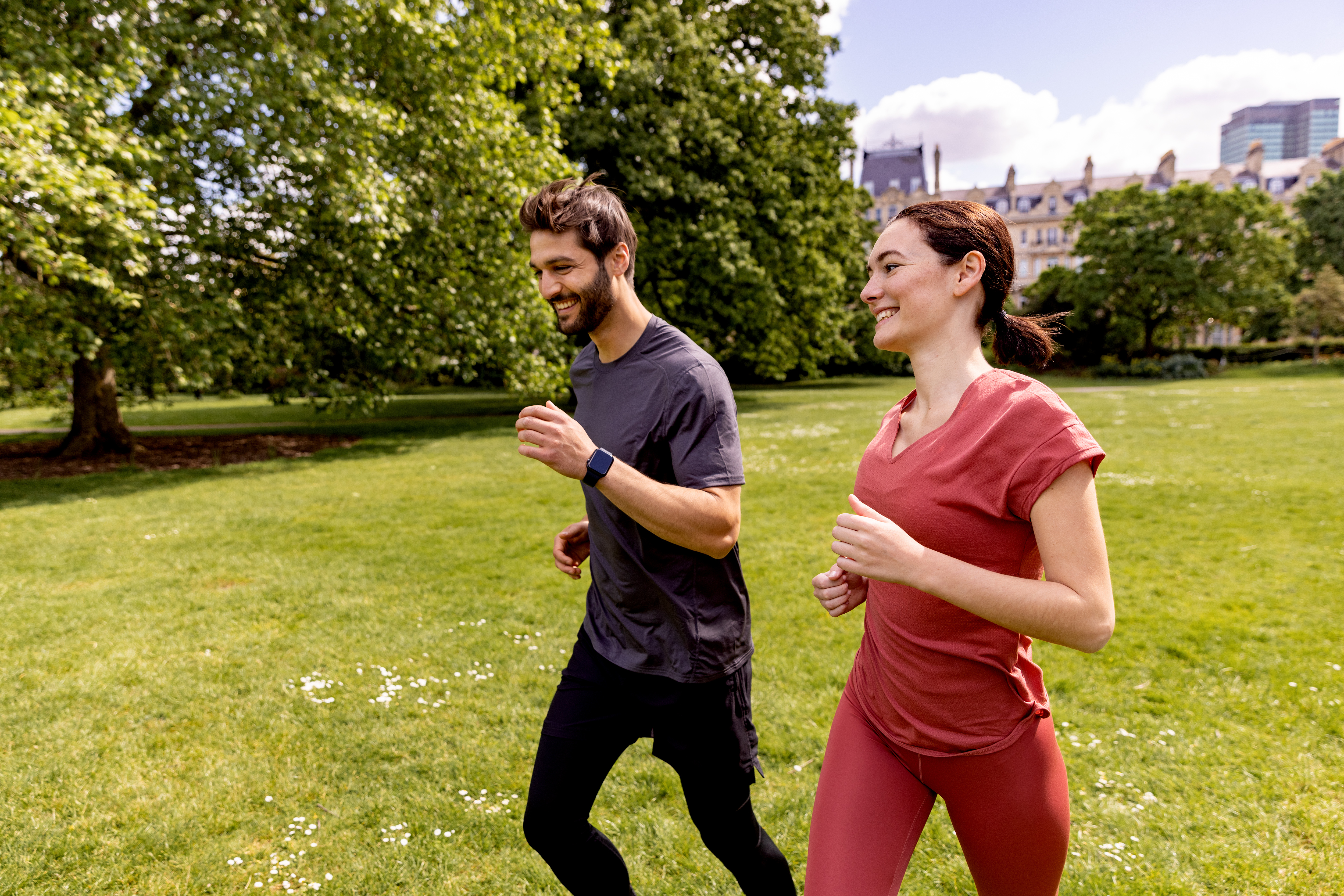 a man and woman running in a park
