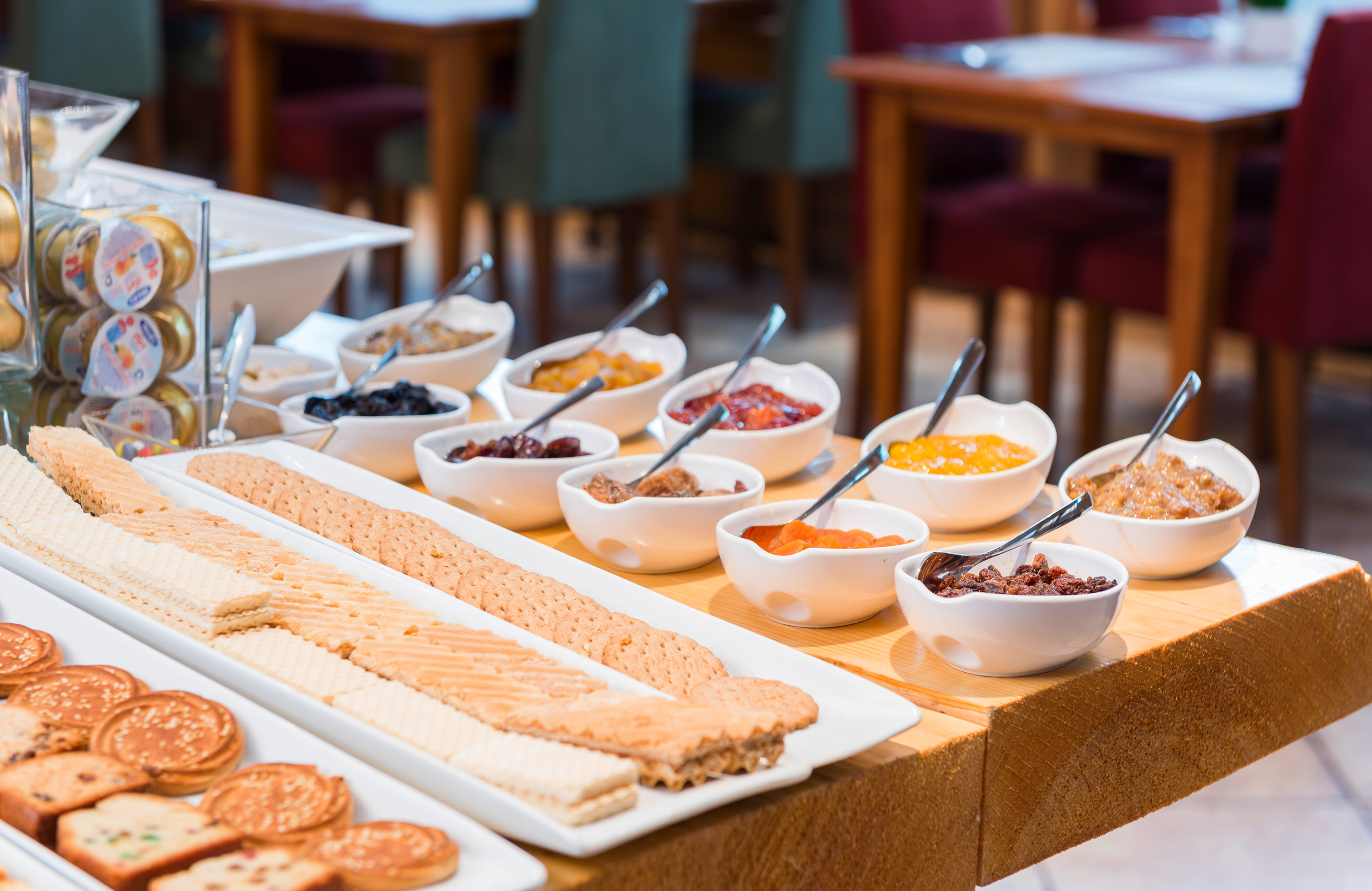 Hotel breakfast buffet: various jams, dried fruits, cookies, and biscuits.