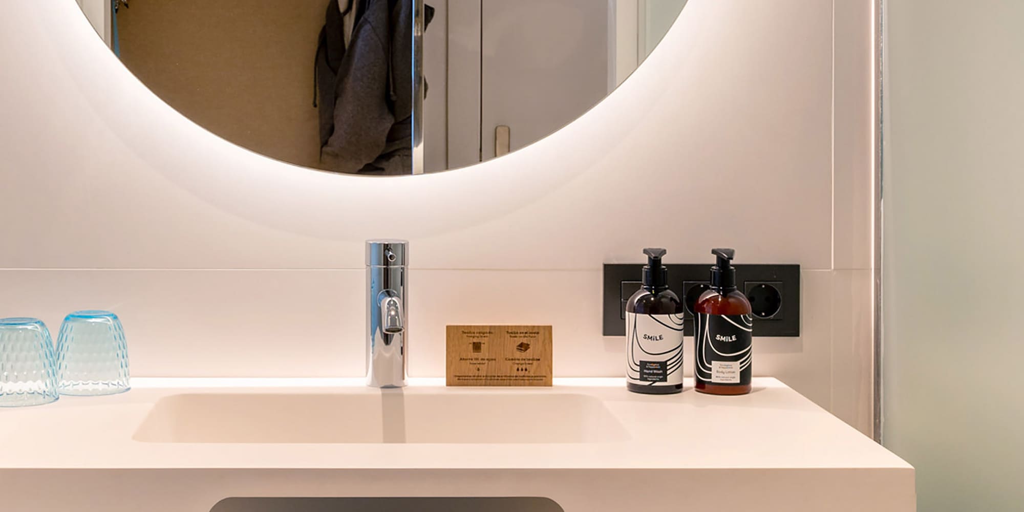 a bathroom sink with a round mirror