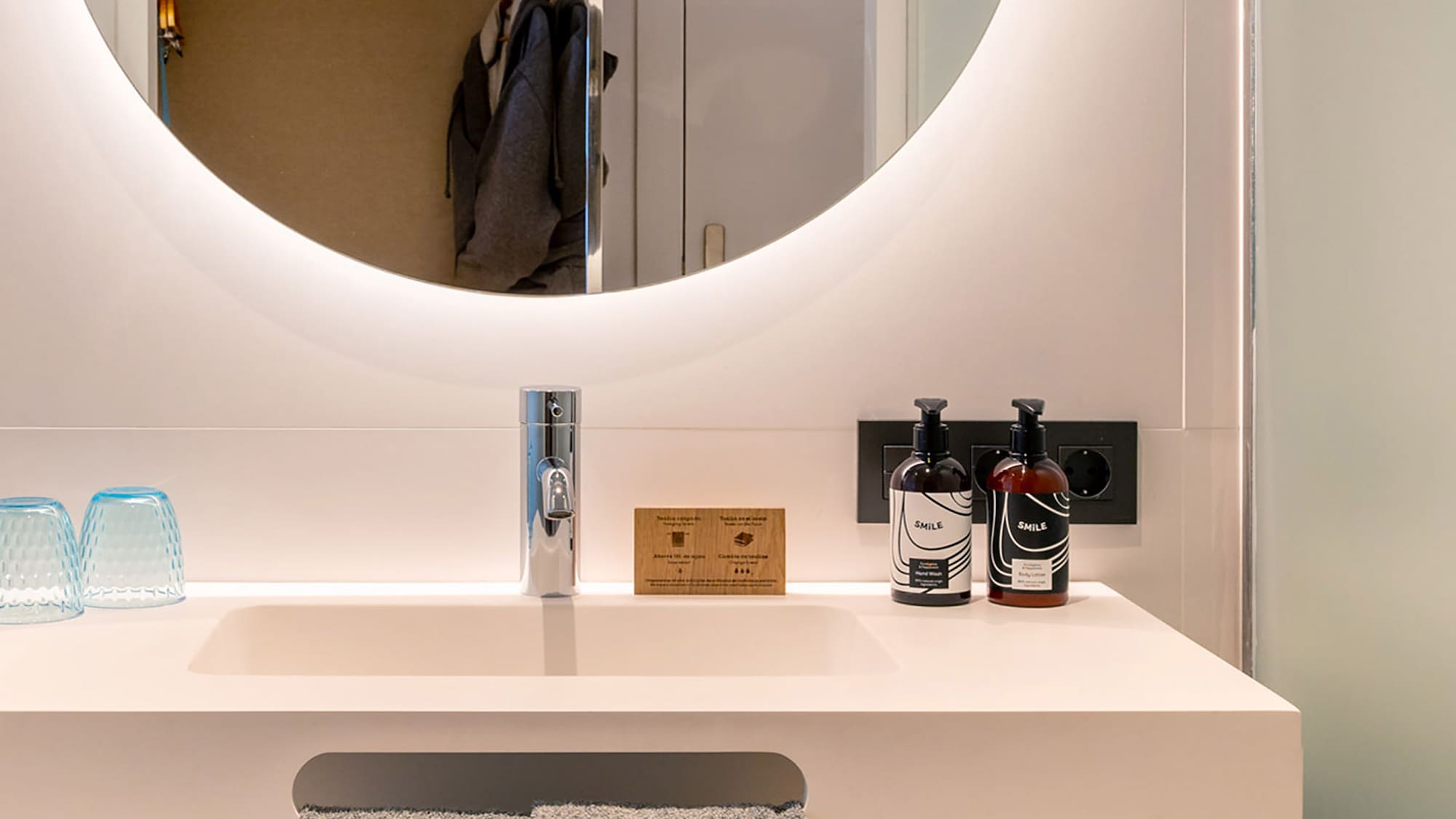 a bathroom sink with a round mirror