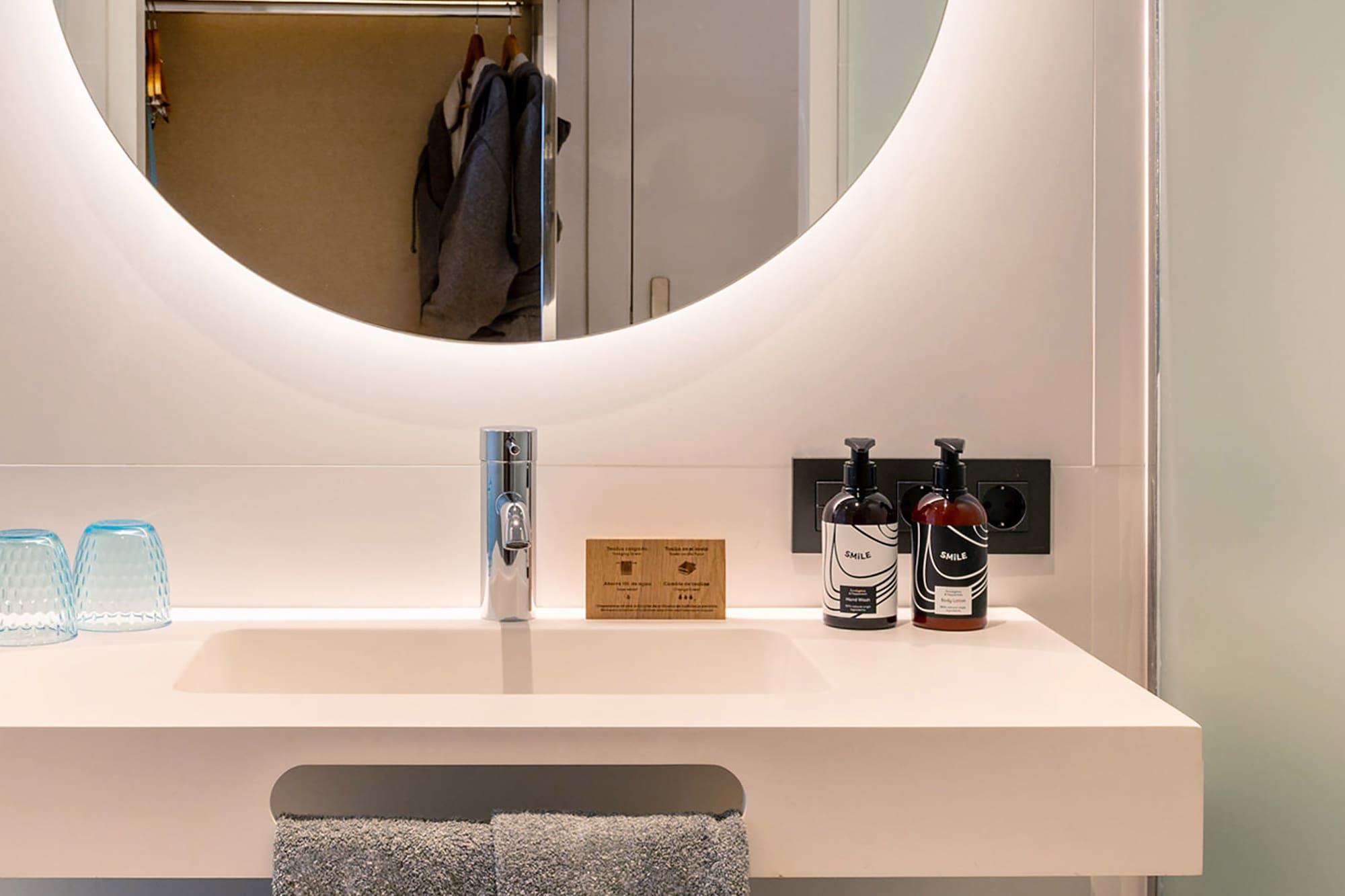 a bathroom sink with a round mirror