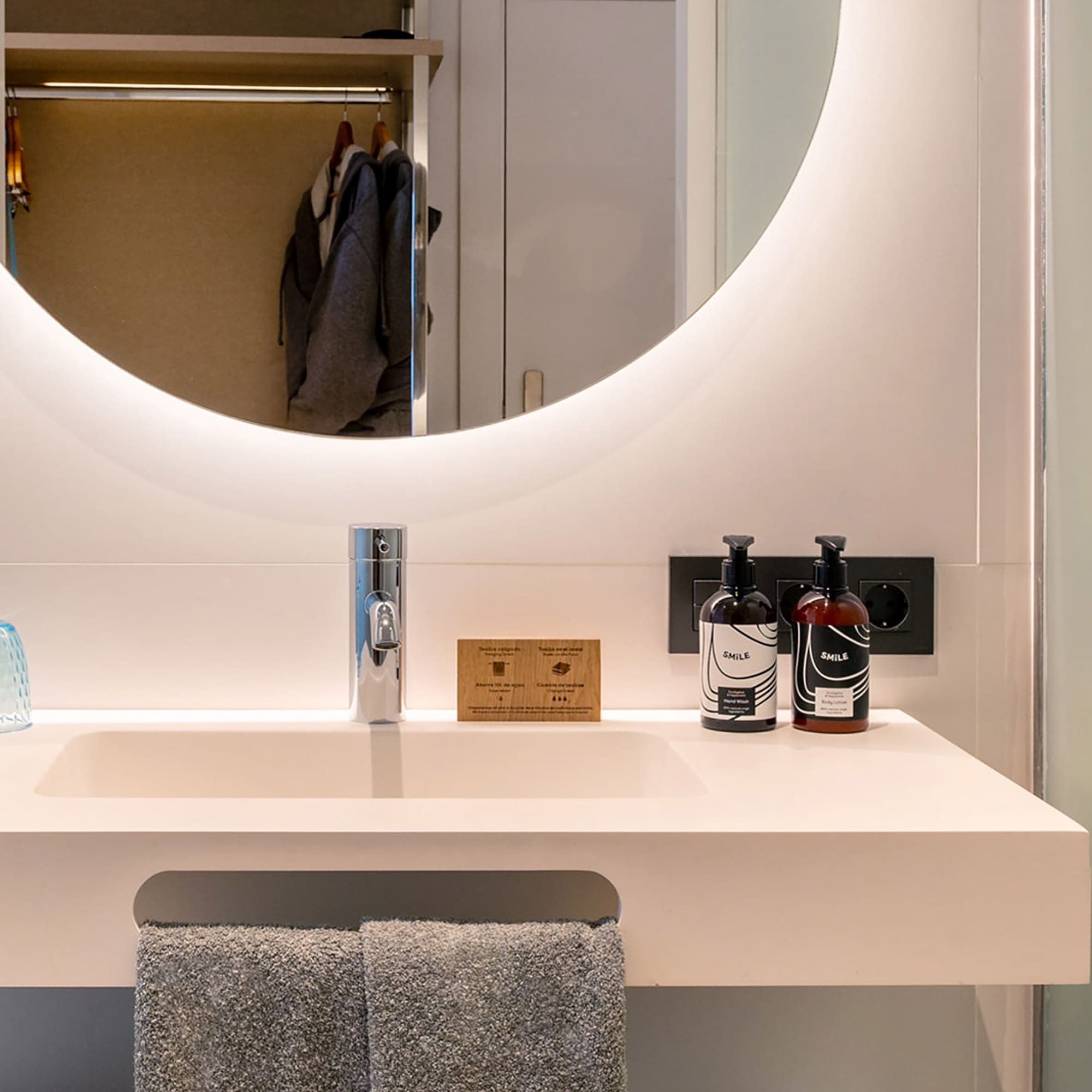 a bathroom sink with a round mirror