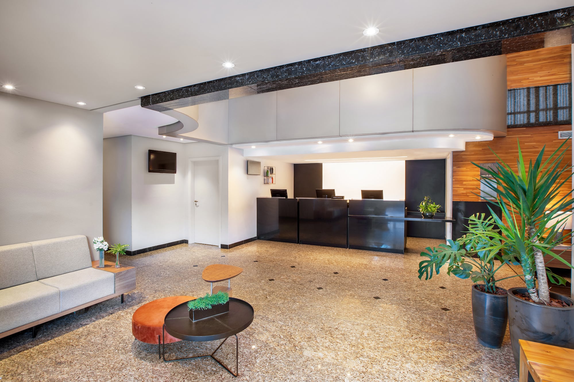 a lobby with a black counter and plants