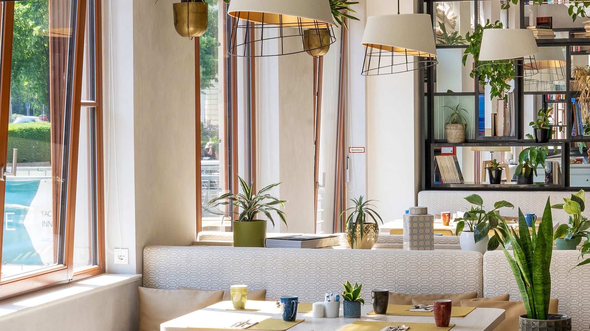 a room with tables and chairs and plants