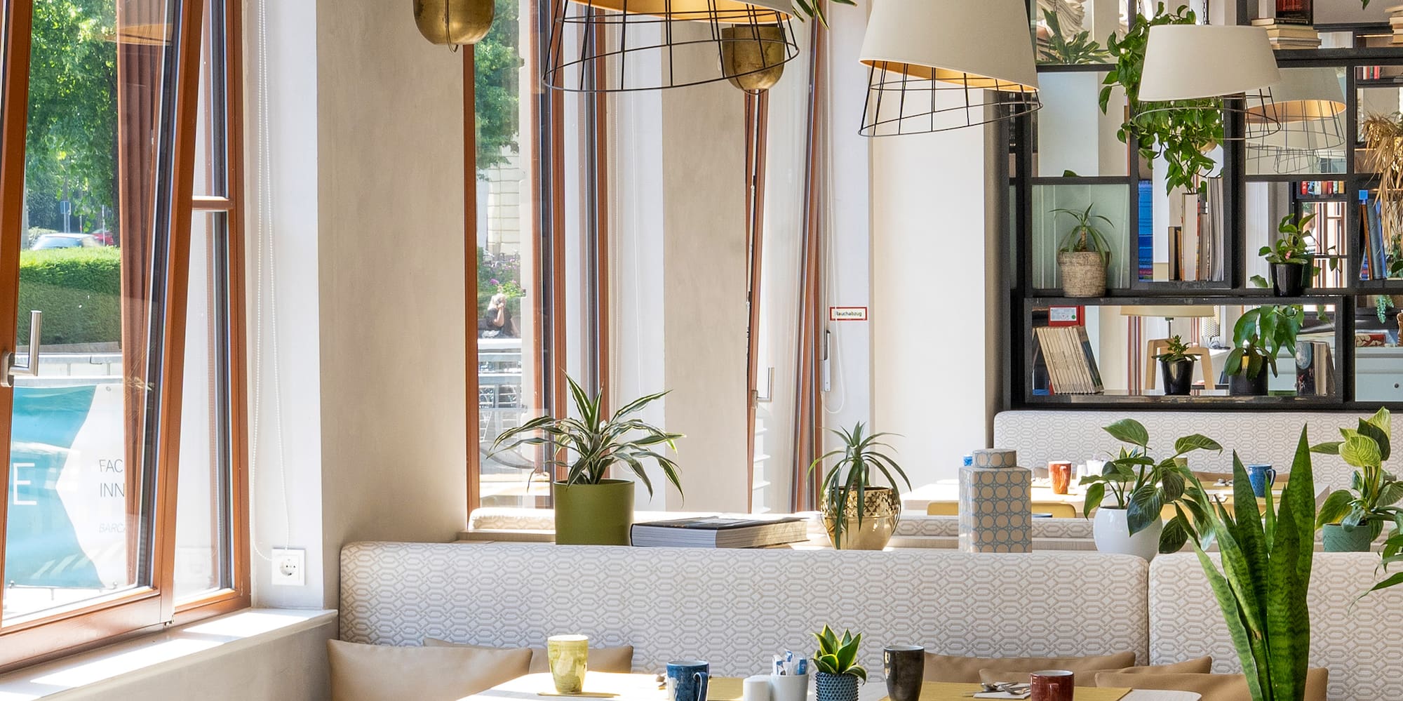 a room with tables and chairs and plants