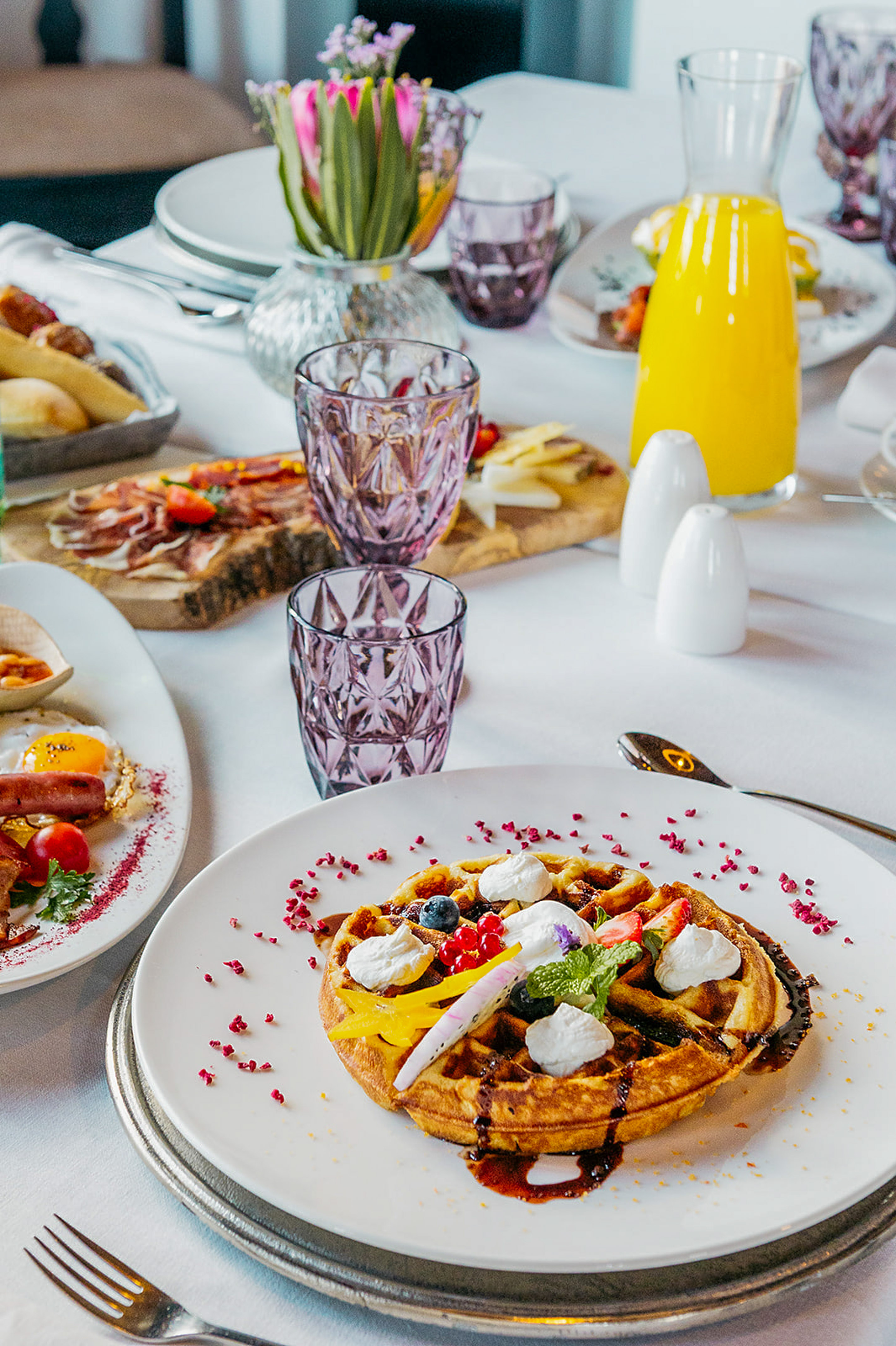 a table with plates of food and glasses