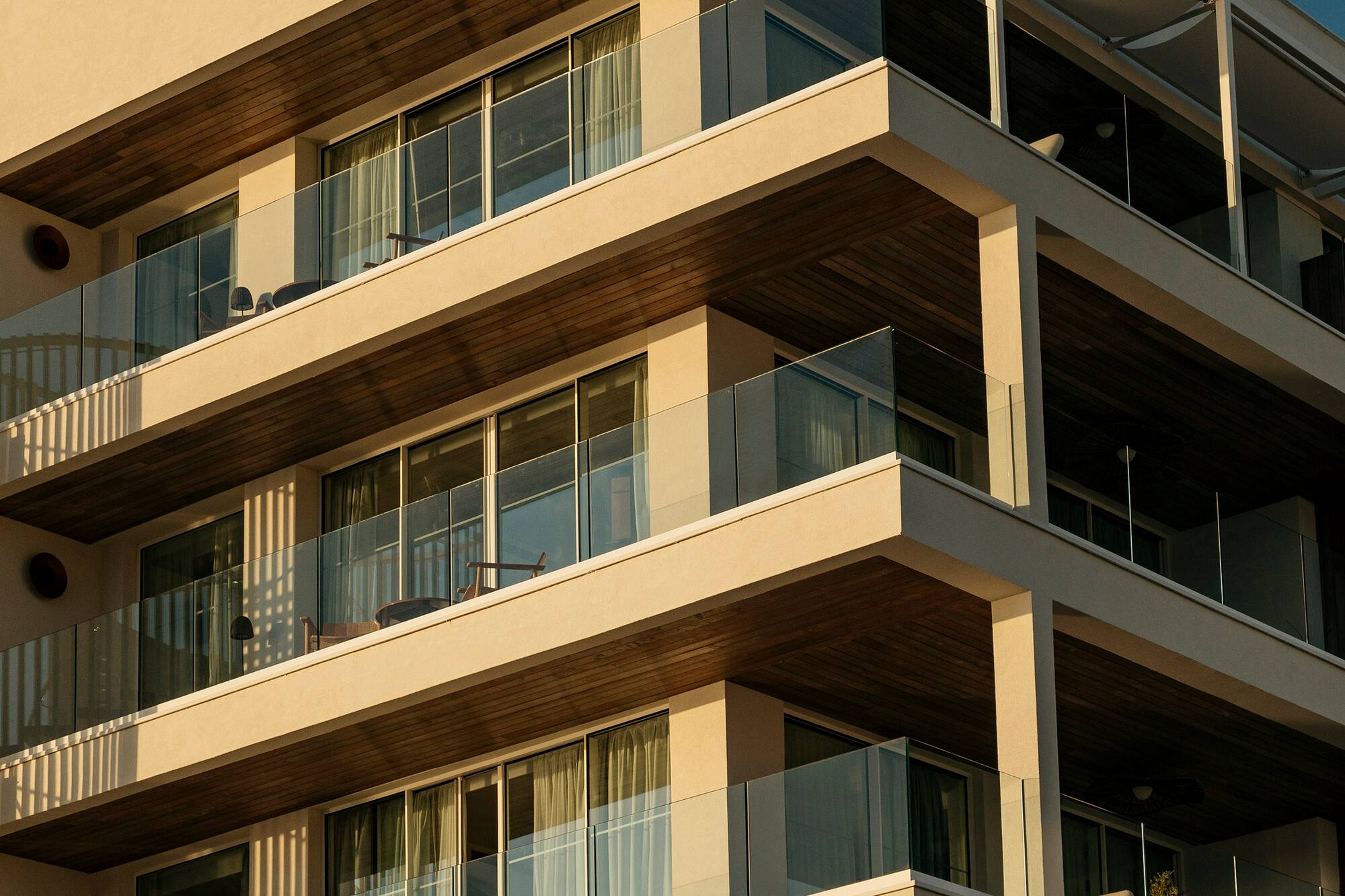 Modern resort building with tiered glass balconies and warm evening light.
