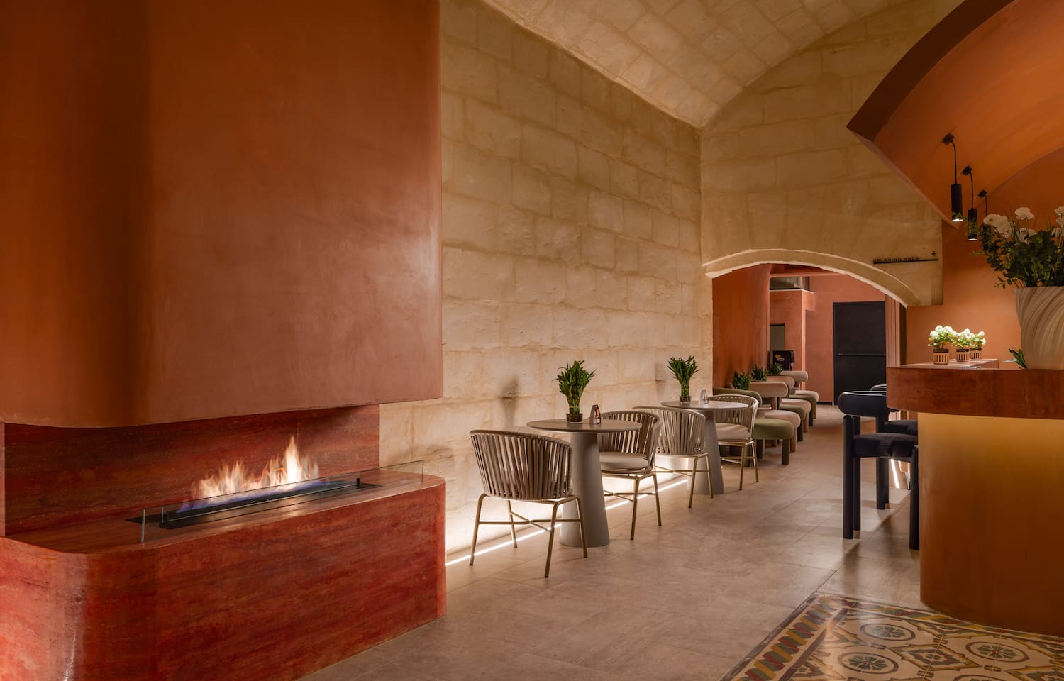 a room with a fireplace and tables and chairs