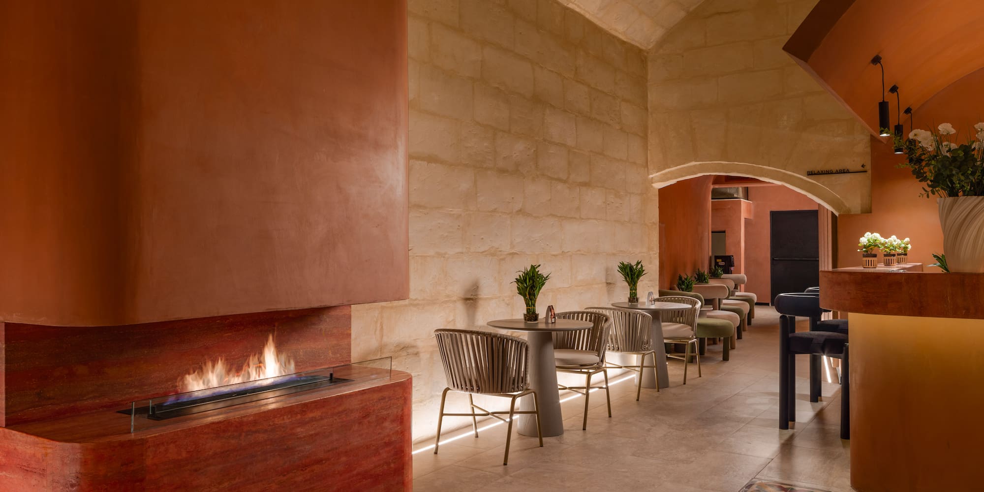 a room with a fireplace and tables and chairs