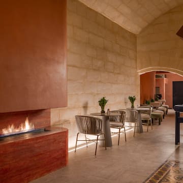 a room with a fireplace and tables and chairs