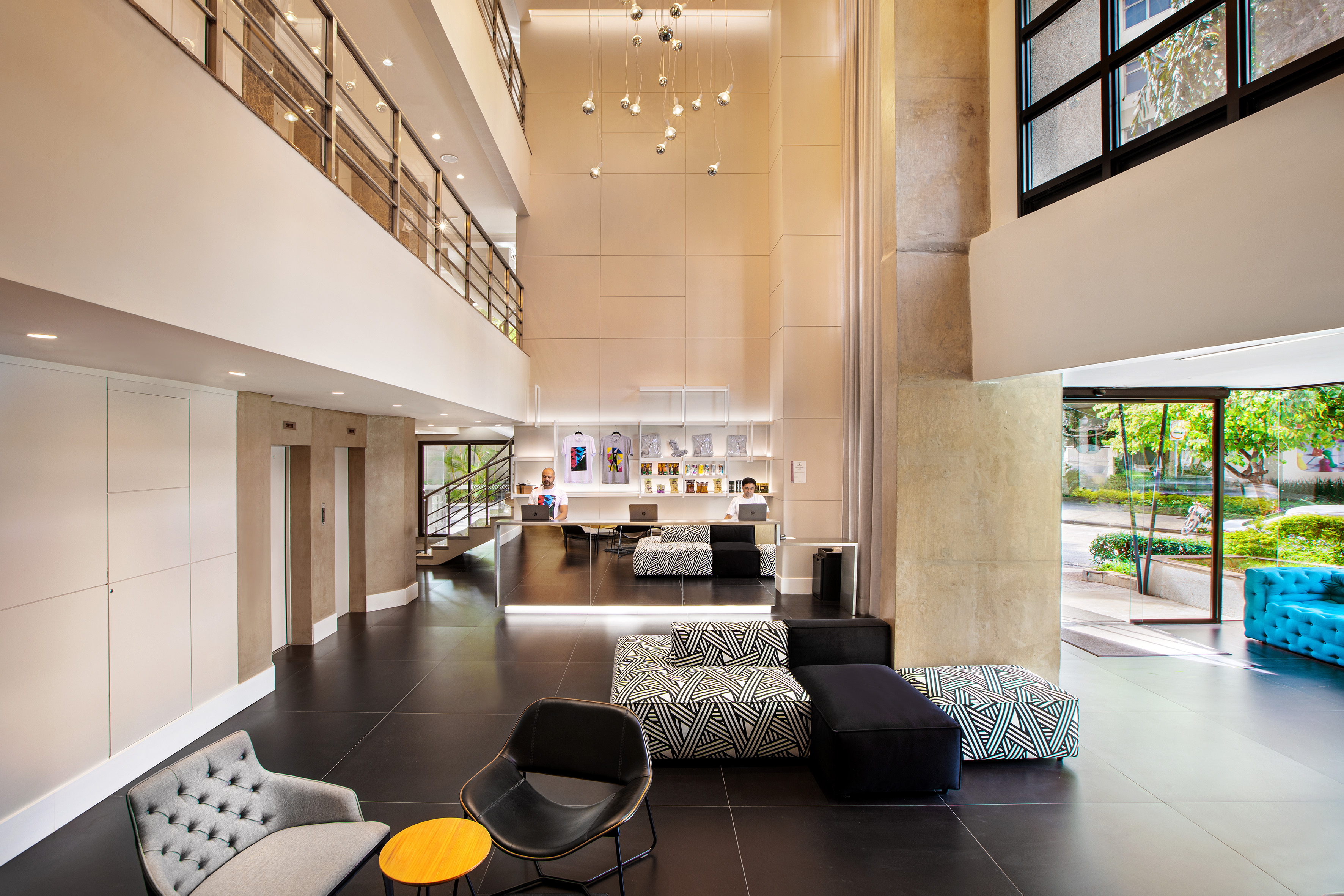 Modern lobby with reception desk, stylish lounge seating, and high ceilings.