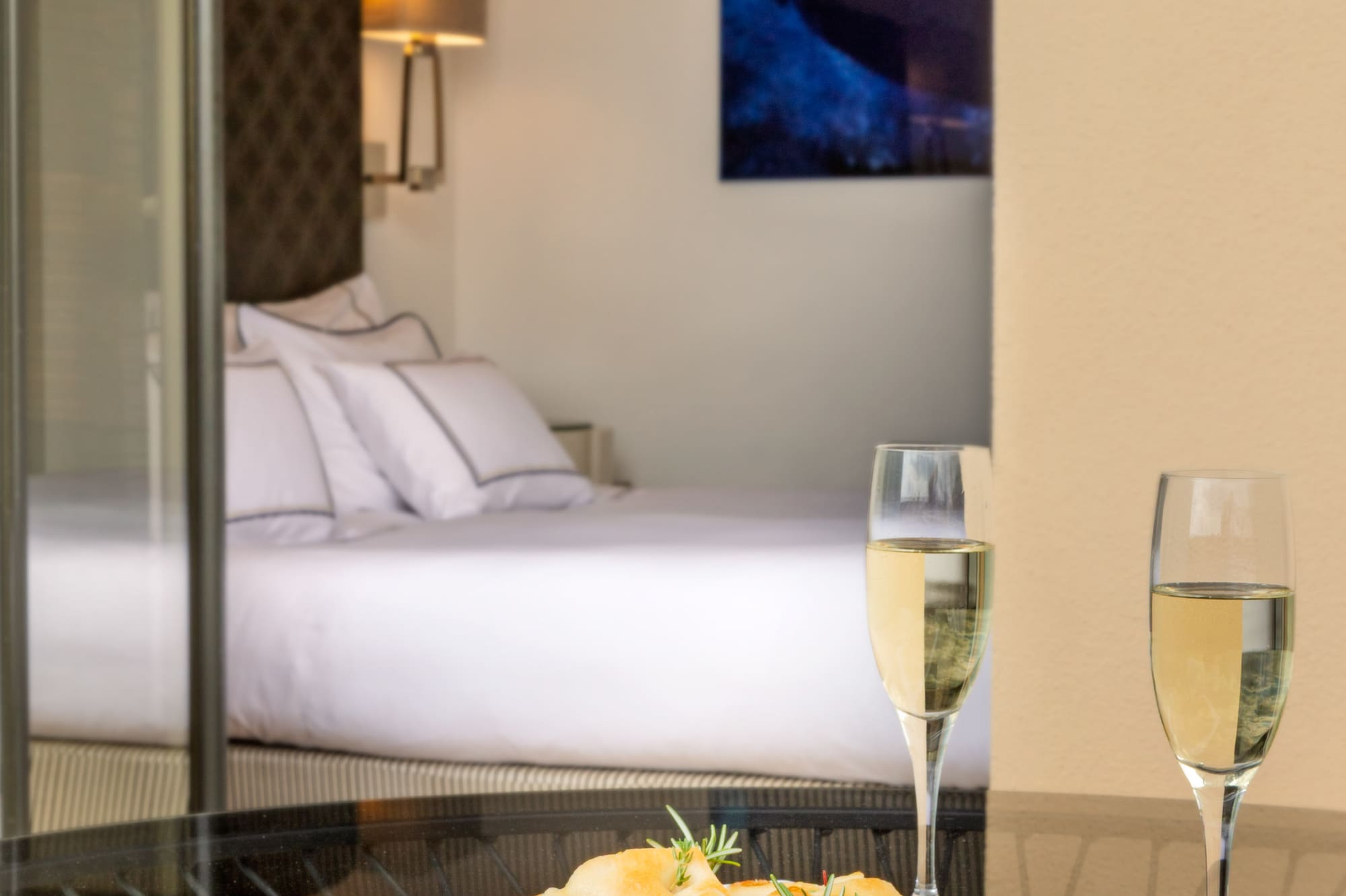 a plate of food and two glasses of champagne