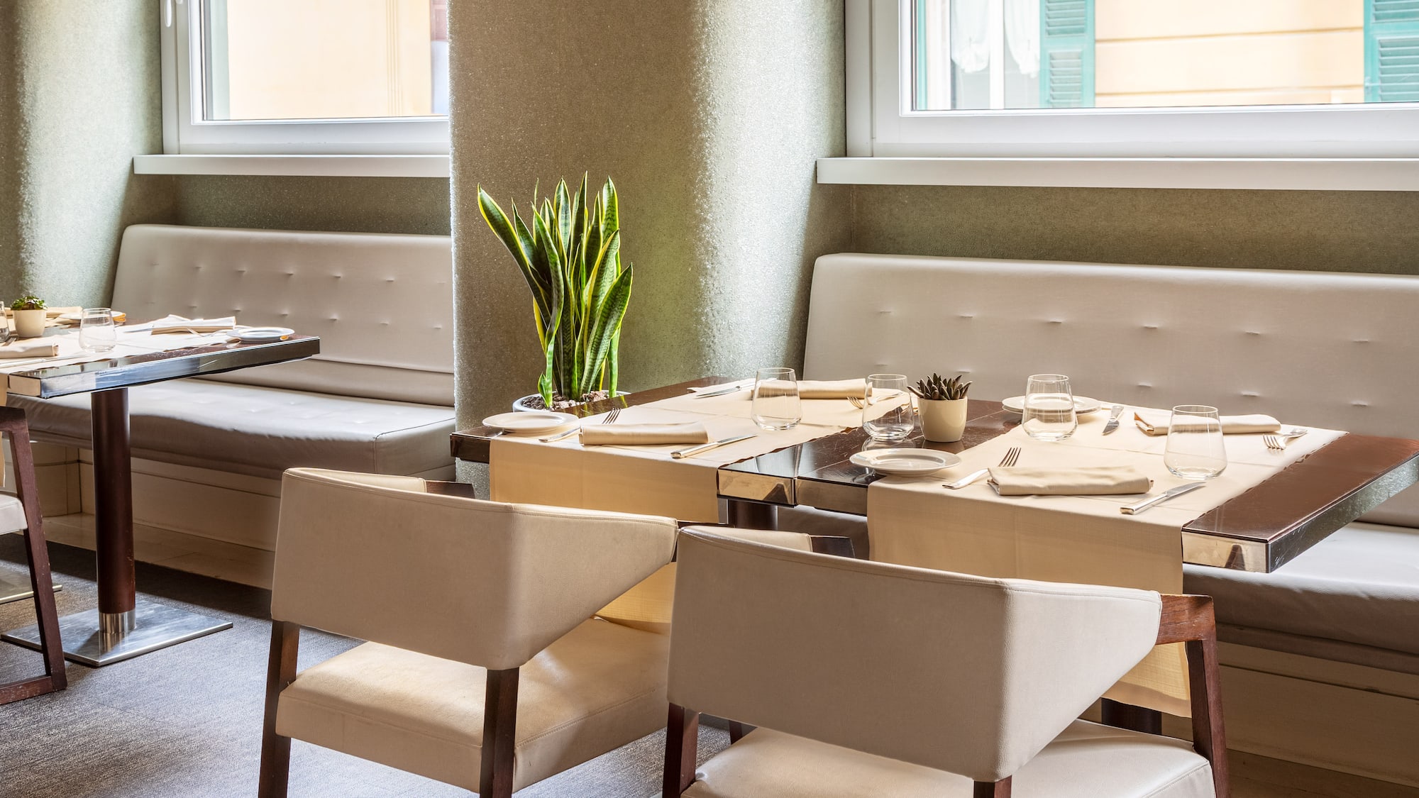 a table with white chairs and a plant in the middle