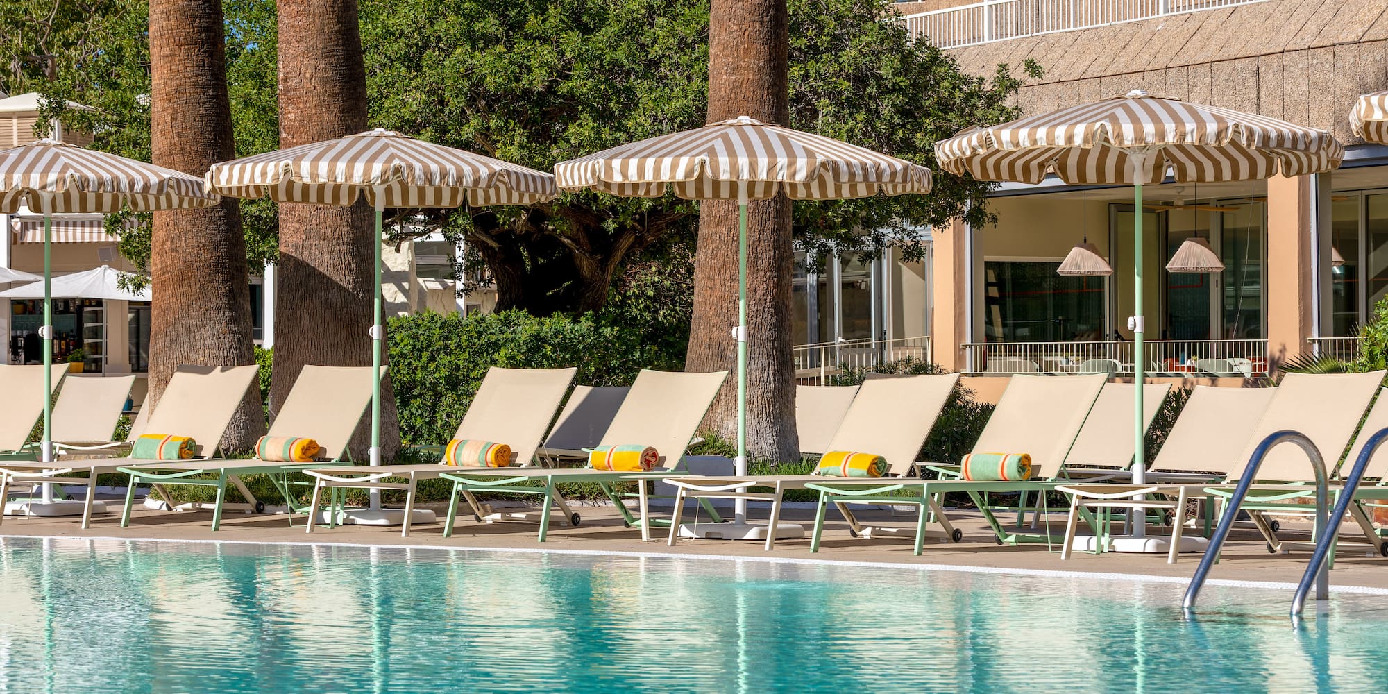 a pool with umbrellas and lounge chairs