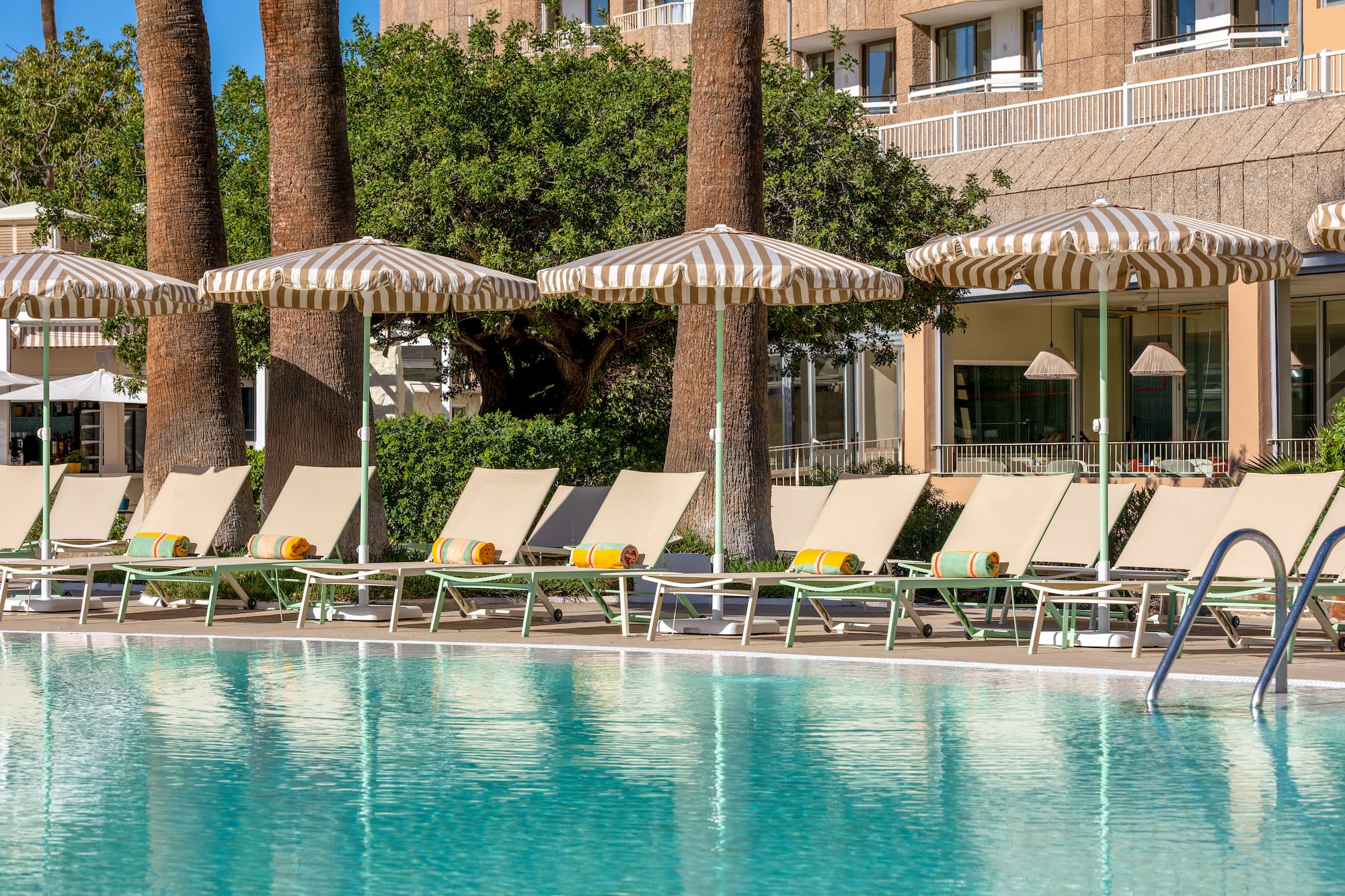 a pool with umbrellas and lounge chairs