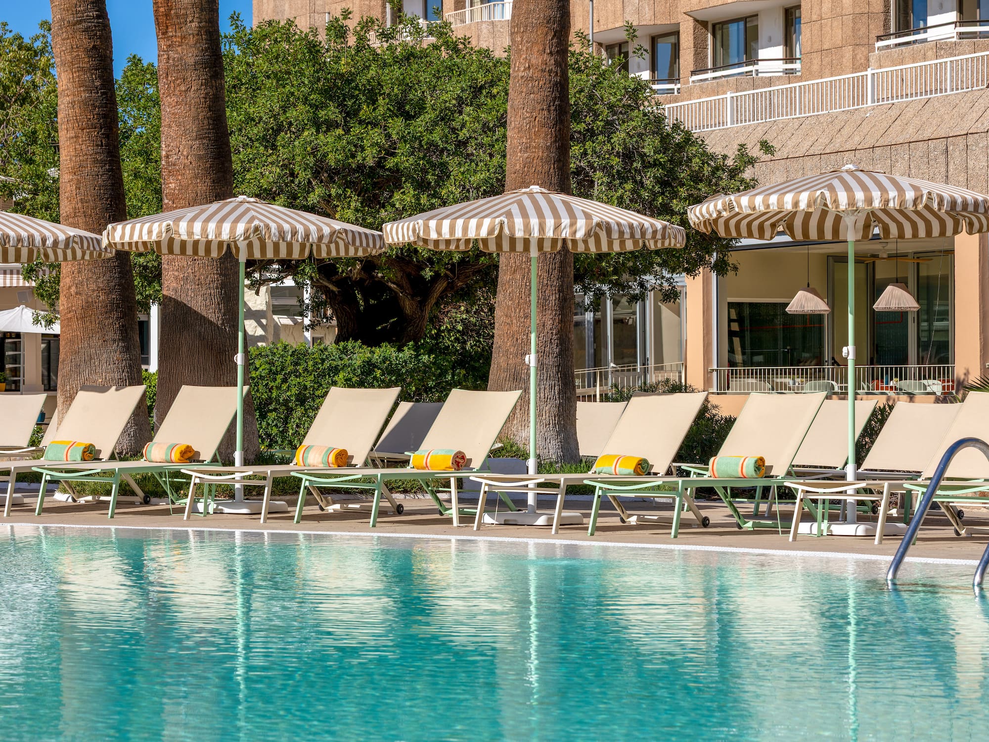 a pool with umbrellas and lounge chairs