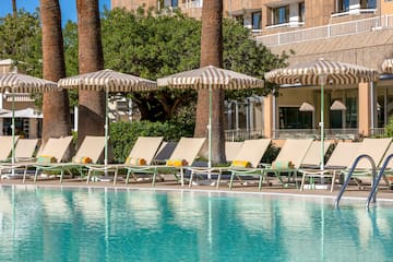 a pool with umbrellas and lounge chairs