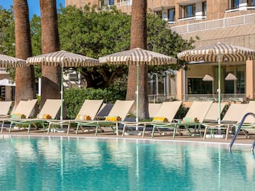 a pool with umbrellas and lounge chairs