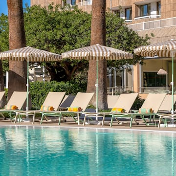 a pool with umbrellas and lounge chairs