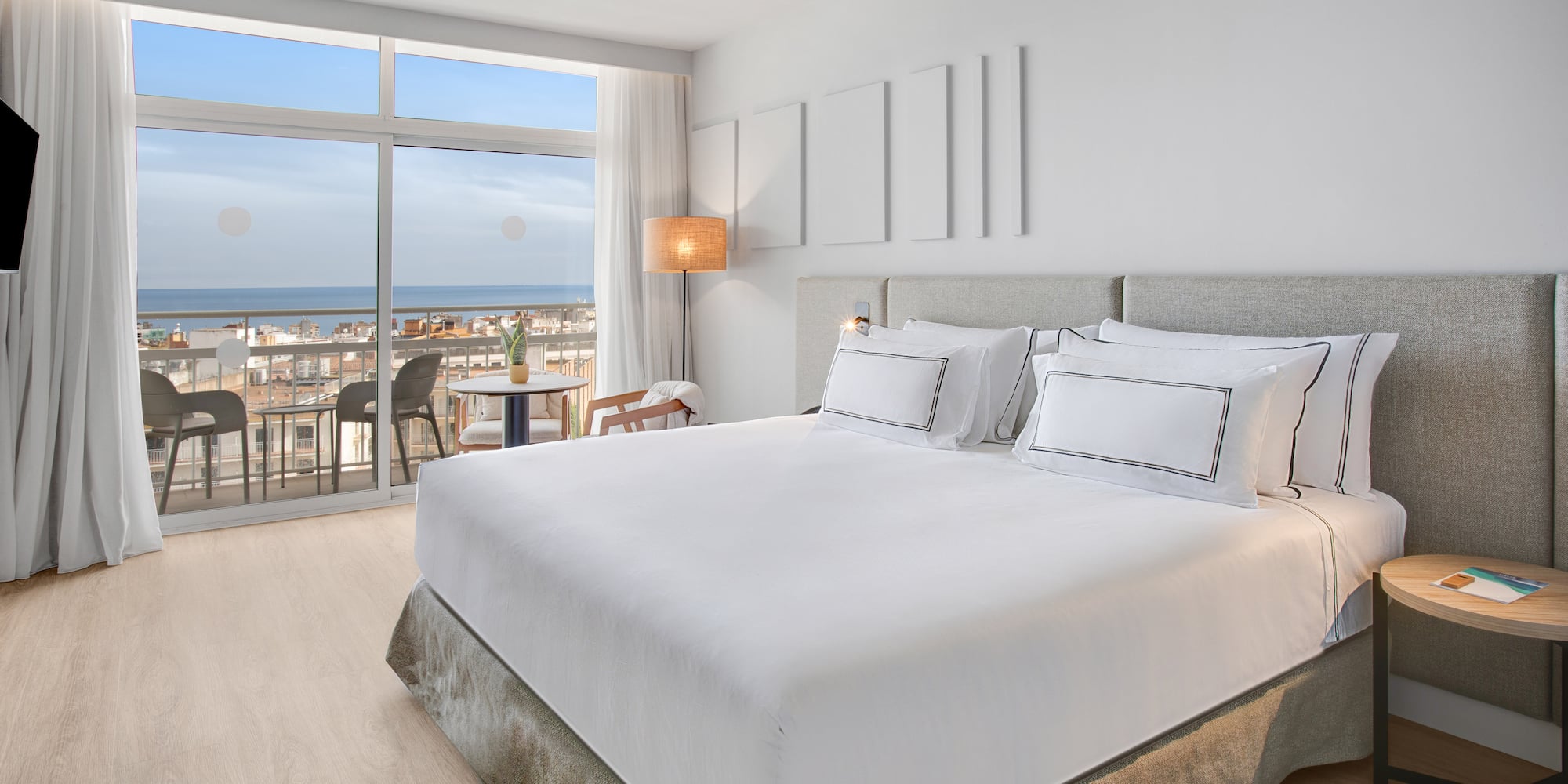 a bedroom with a large window overlooking the ocean