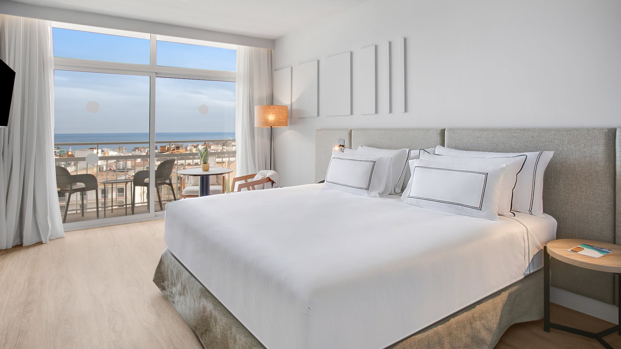 a bedroom with a large window overlooking the ocean