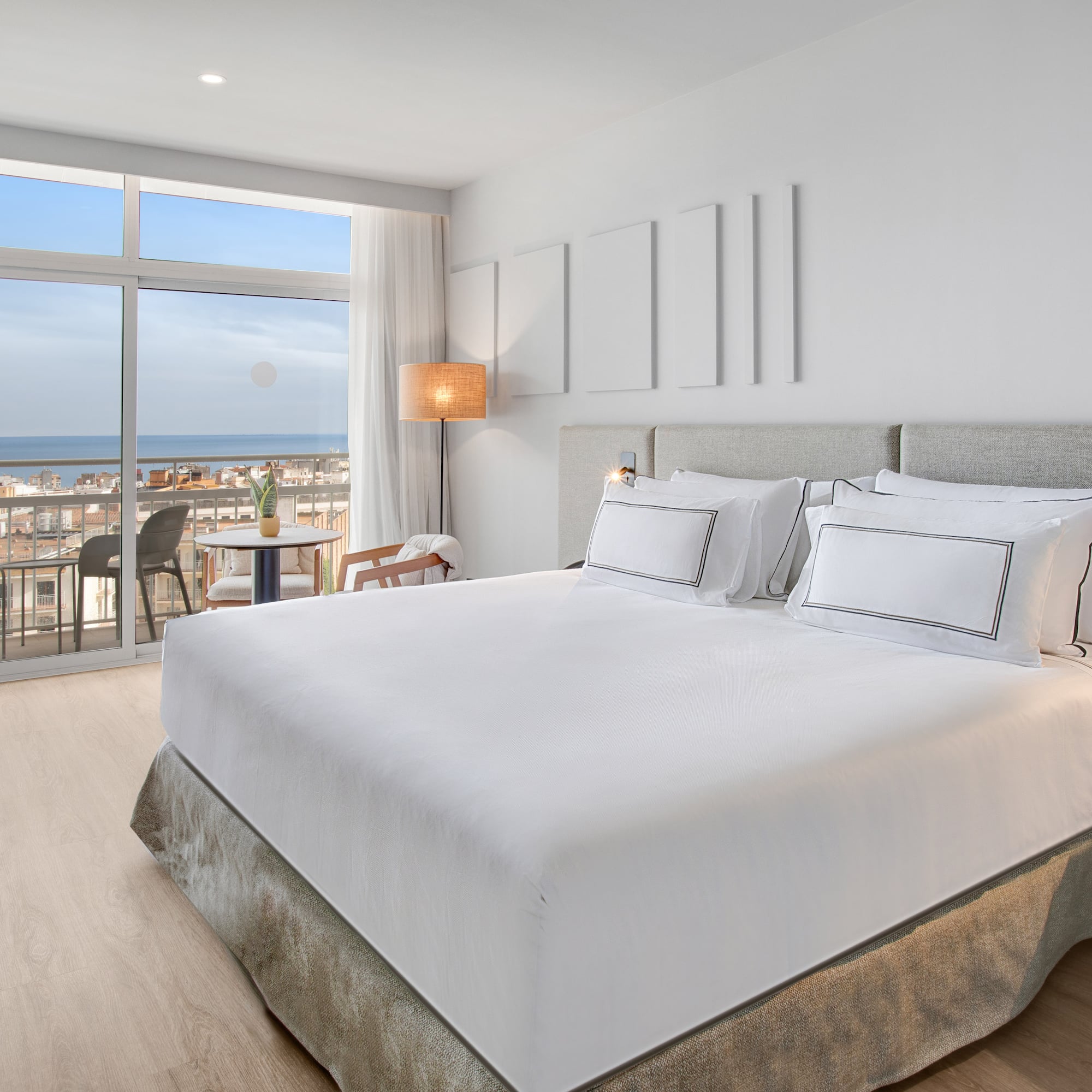 a bedroom with a large window overlooking the ocean
