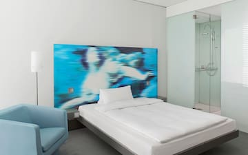 a bed with a blue and white picture on the wall